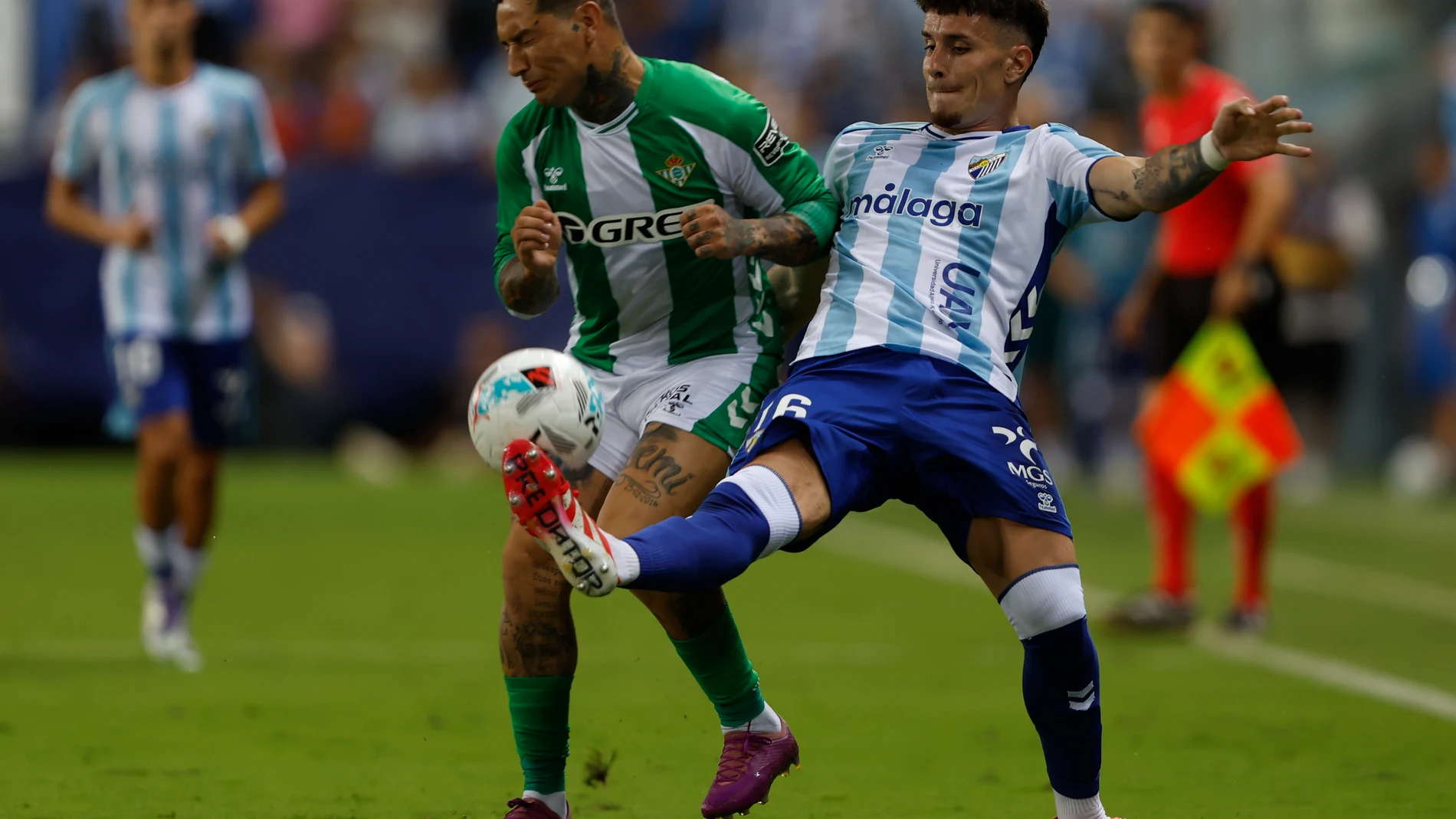 MÁLAGA, 09/08/2025.- El delantero del Betis Chimy Ávila (i) lucha con Murillo, del Málaga, durante el partido del Torneo Costa del Sol que Málaga CF y Real Betis disputan hoy sábado en el estadio de La Rosaleda. EFE/Jorge Zapata