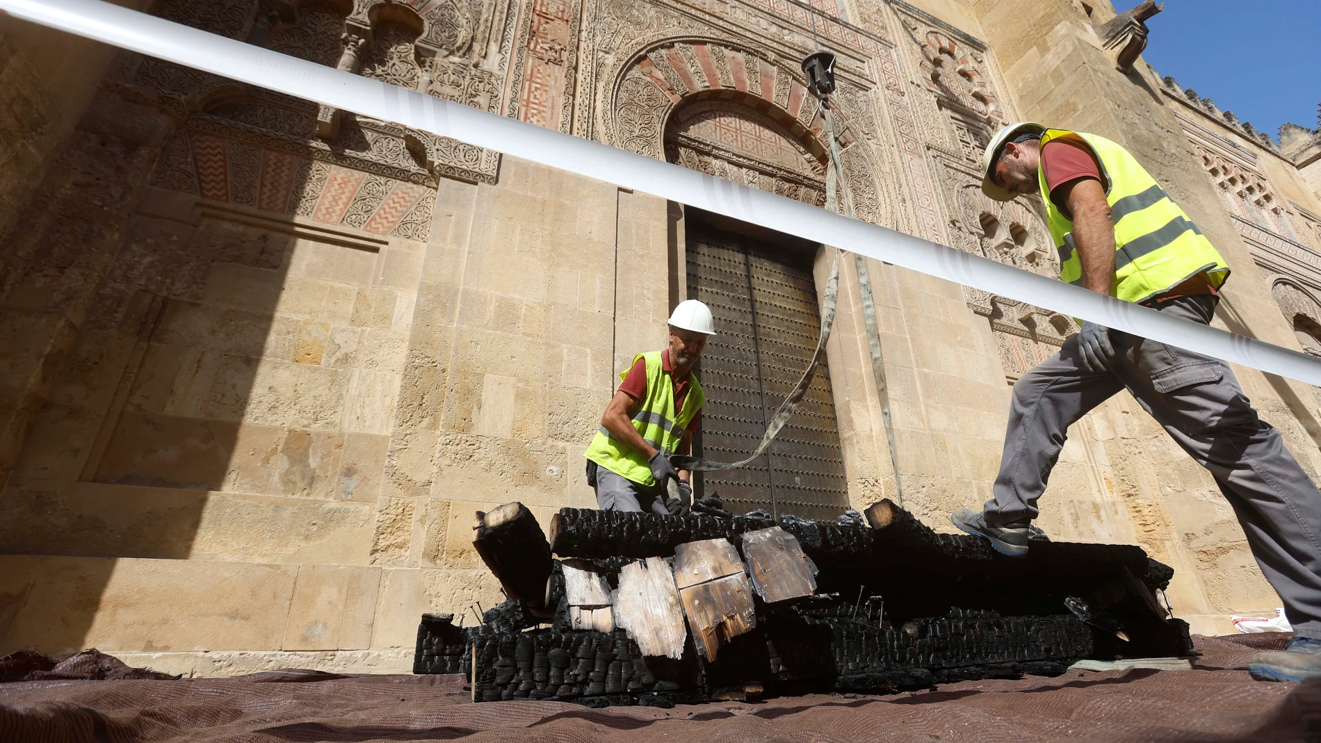 GRAFAND255. CÓRDOBA, 12/08/2025.-Operarios trabajan en el exterior de la Mezquita-Catedral de Córdoba, que fue afectada en las cubiertas sobre todo en el techo de la capilla de la Anunciación, que fue la que colapsó a causa del incendio declarado el pasado viernes en una de las capillas, este martes durante la visita que el presidente de ICOMOS España, Juan Carlos Molina, ha realizado al monumento para conocer los daños que ha sufrido. EFE/Salas