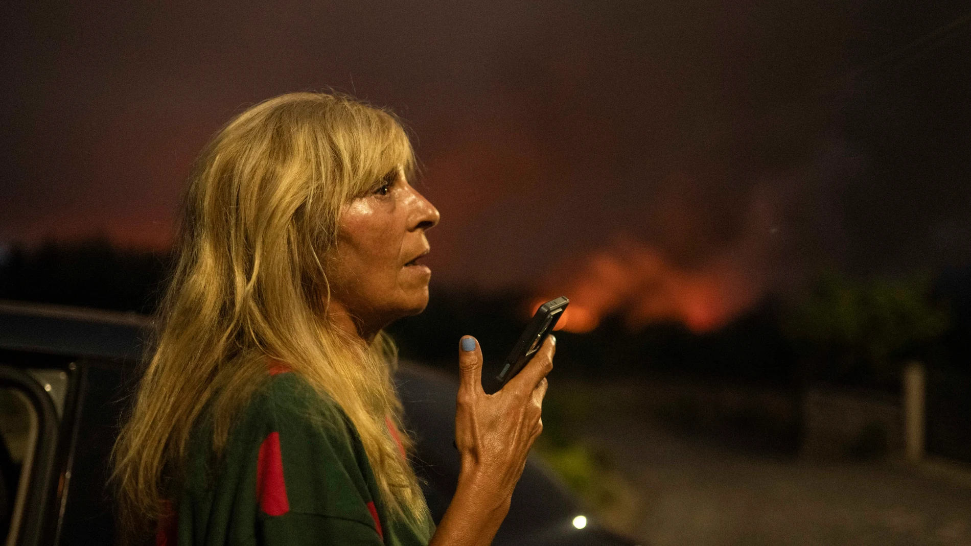 CARBALLEDA DE AVIA (OURENSE), 16/08/2025.- Una mujer pide ayuda por teléfono ante el avance del incendio forestal en Carballeda de Avia (Ourense). EFE/ Brais Lorenzo