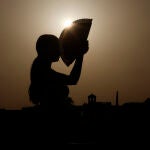 Una persona se abanica al atardecer en una jornada de altas temperaturas en la ciudad de Córdoba