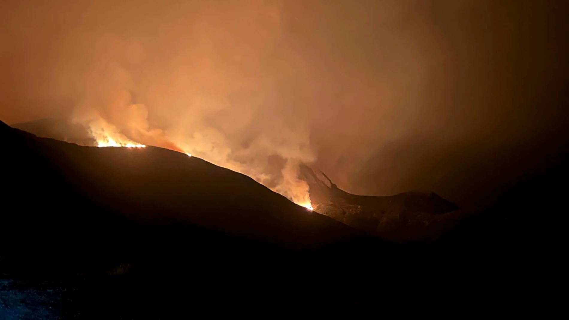 REAL CONCEJO DE VALDEÓN, 17/08/2025.- Fotografía cedida que muestra el incendio que afecta a la vertiente leonesa del Parque Nacional de Picos de Europa, tras su inicio en la noche de ayer, sábado, y que ha obligado a ordenar el desalojo de 8 poblaciones del Valle de Valdeón, aunque buena parte de los vecinos ha optado por no dejar sus viviendas, ante el temor de que la escasez de medios de extinción pueda conllevar que el fuego llegue a las casas. El alcalde pedáneo del Real Concejo de Valde...