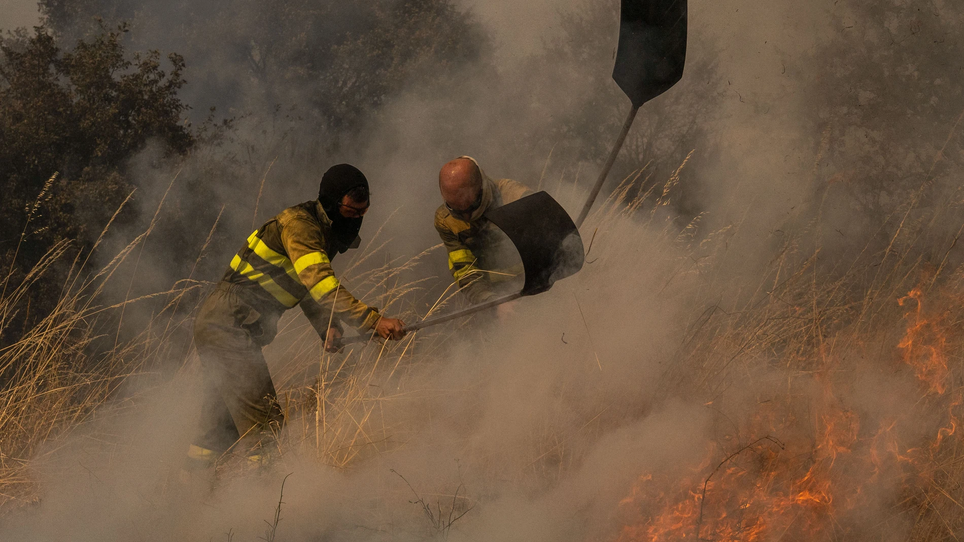 OÍMBRA (OURENSE), 19/08/2025.- Dos voluntarios realizan labores de extinción en el incendio de Oímbra (Ourense) este martes. El incendio de Oímbra lleva devoradas 12.000 hectáreas de acuerdo con cifras de la Xunta (20.500 según estimaciones de expertos basadas en mapas satelitales), mientras que Cipérez, en Salamanca, lleva unas 10.500 y Porto de Sanabria, en Zamora, 10.300EFE/ Brais Lorenzo