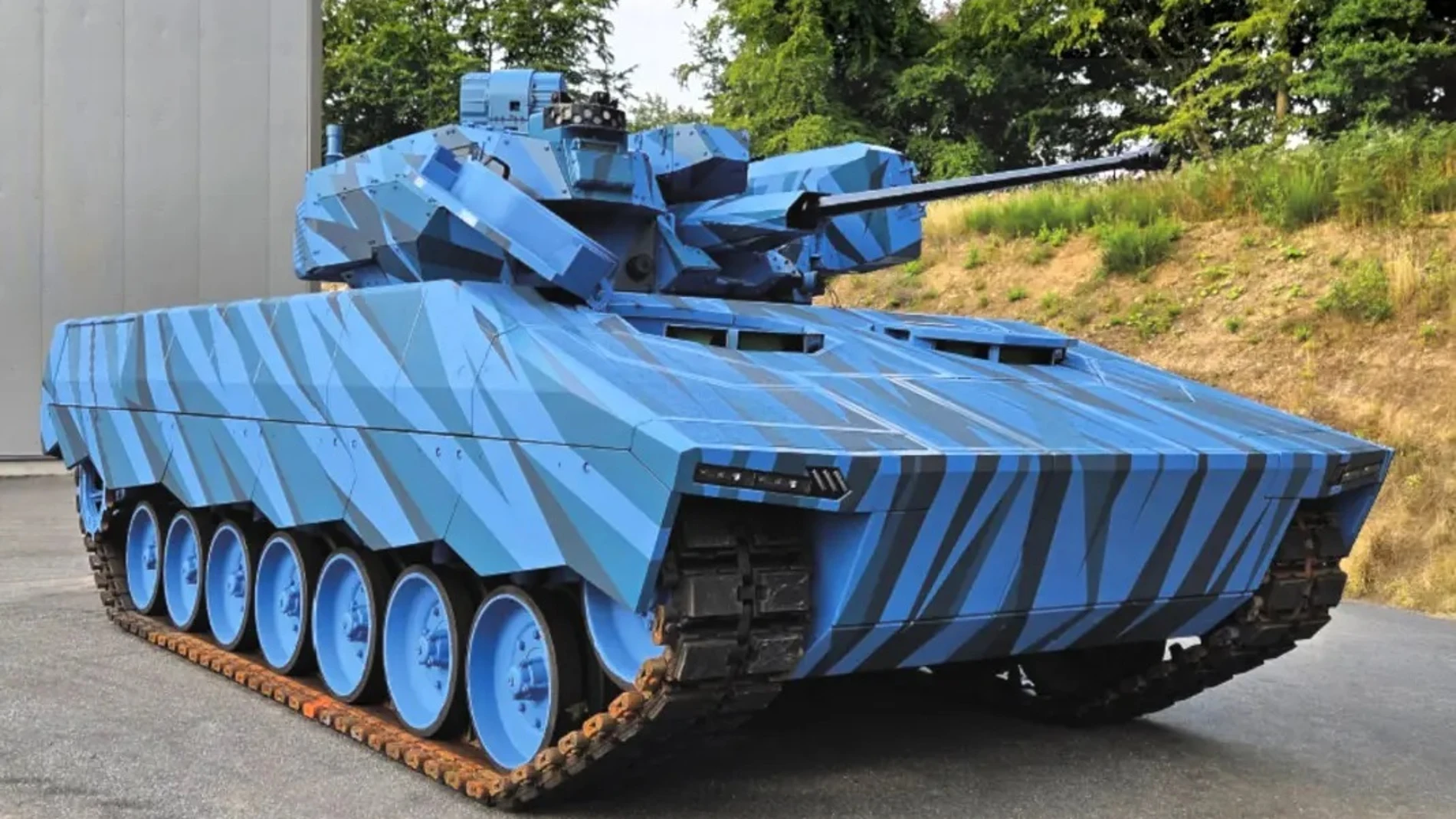 Aparece un vehículo blindado con una torreta y un cañón automático, está todo pintado de color azul