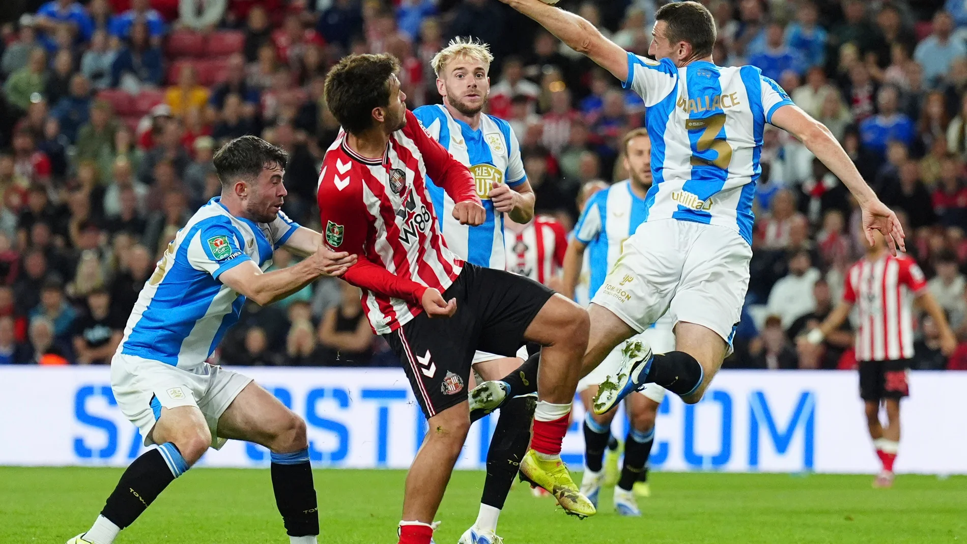 Huddersfield Town's Murray Wallace, right, and Sunderland's Marc Guiu during the English League Cup second round match between Sunderland and Huddersfield Town at Stadium of Light, Sunderland, England, Tuesday Aug. 26, 2025. (Owen Humphreys/PA via AP)