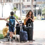Turistas con sus maletas en la plaza del Ayuntamiento de Valencia