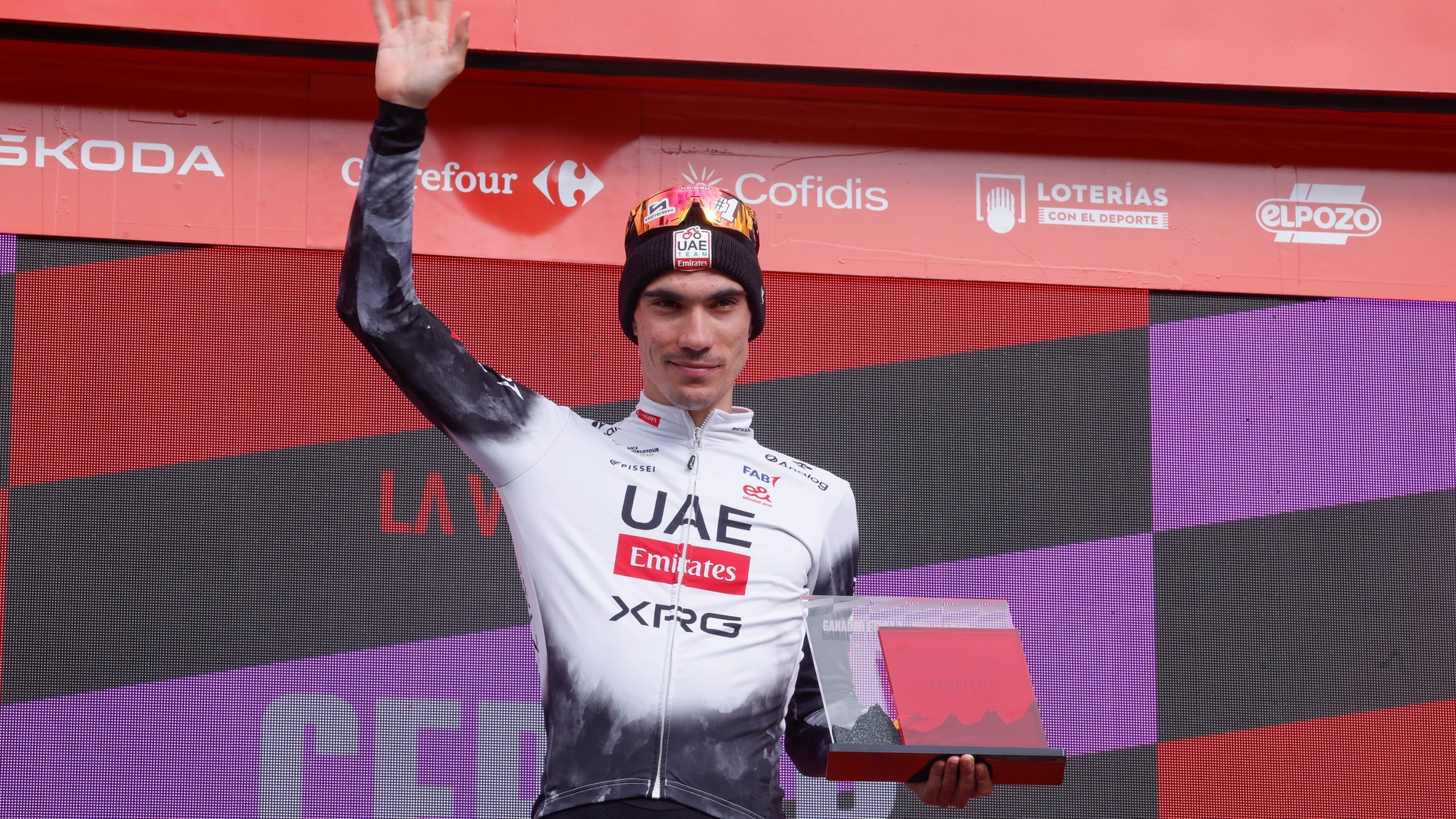 CERLER (HUESCA), 29/08/2025.- El ciclista español del Emirates UAE Juan Ayuso celebra en el podio su victoria en la séptima etapa de la Vuelta Ciclista a España que vive este viernes su segunda jornada montañosa con salida en Andorra La Vella y llegada en Cerler (Huesca) tras 187 kilómetros de recorrido. EFE/Javier Lizón