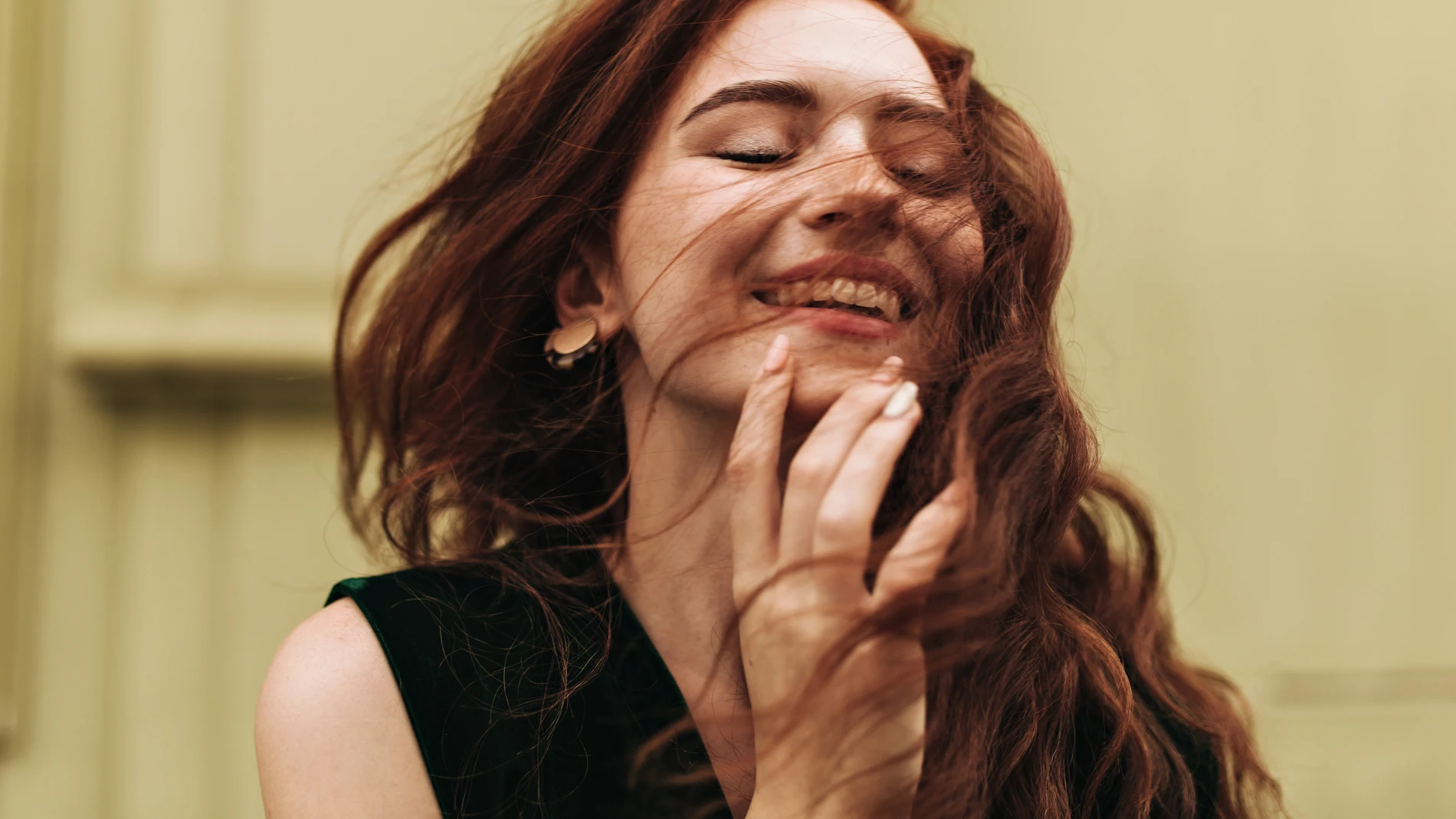 Mujer joven con el pelo largo sonriendo al aire libre.