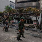 Militares pasan junto a un autobús en llamas en medio de las protestas en Yakarta