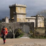 Un peregrino deja atrás el Castillo de Pambre. 