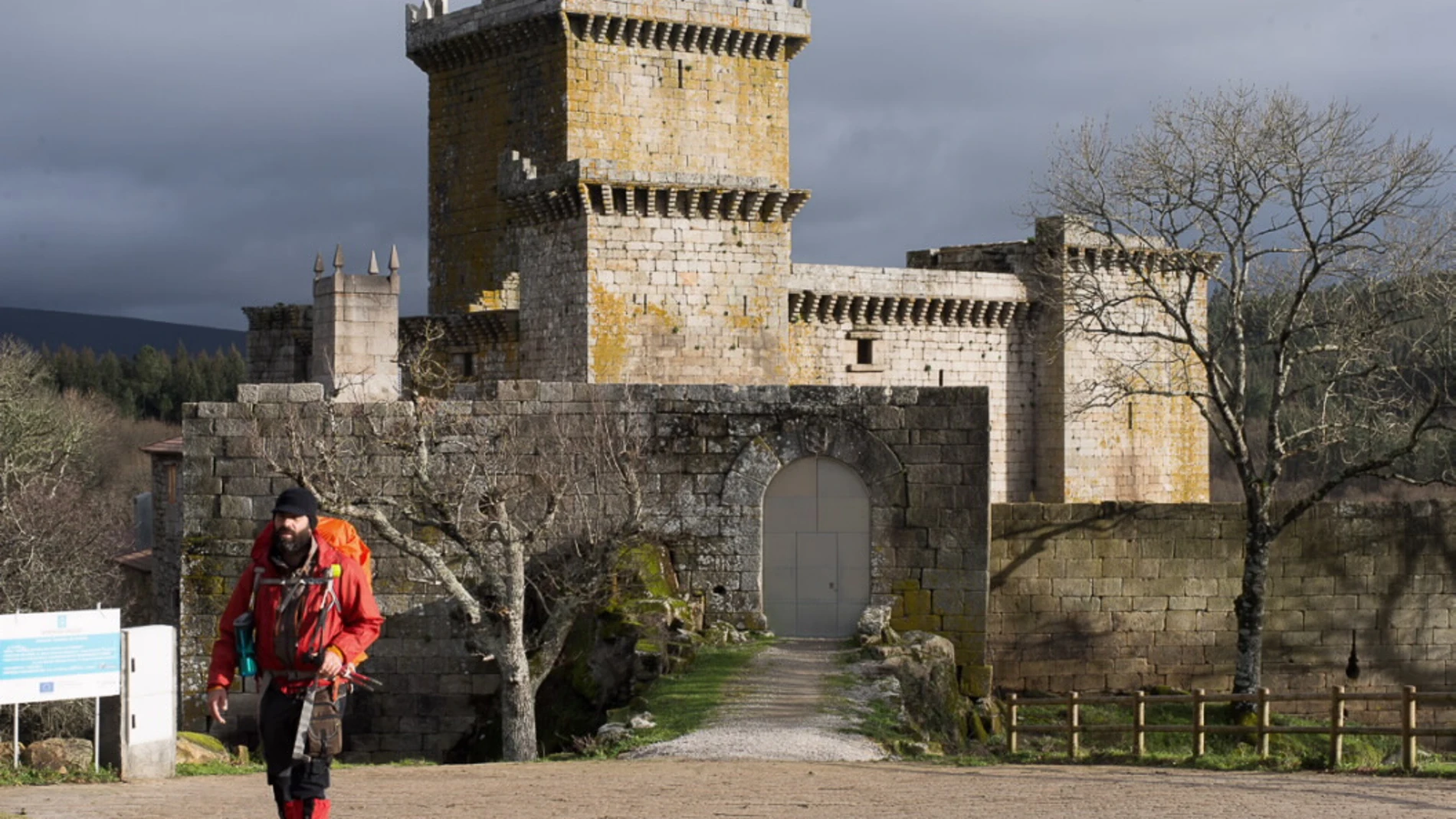 Un peregrino deja atrás el Castillo de Pambre.