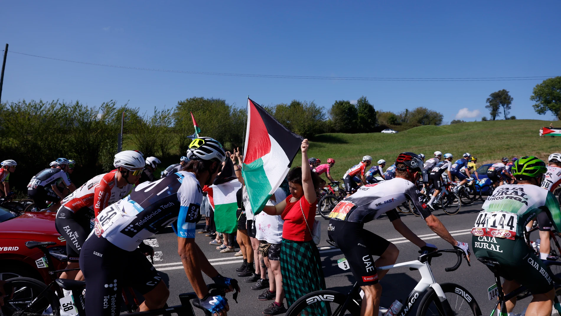 CABEZÓN DE LA SAL (CANTABRIA), 05/09/2025.- Varias personas protestan en apoyo al pueblo palestino entre los ciclistas durante la etapa 13 de la Vuelta Ciclista a España 2025 disputada entre el Cabezón de la Sal, y L'Angliru, de 202,7km de recorrido, este viernes. EFE/Javier Lizón