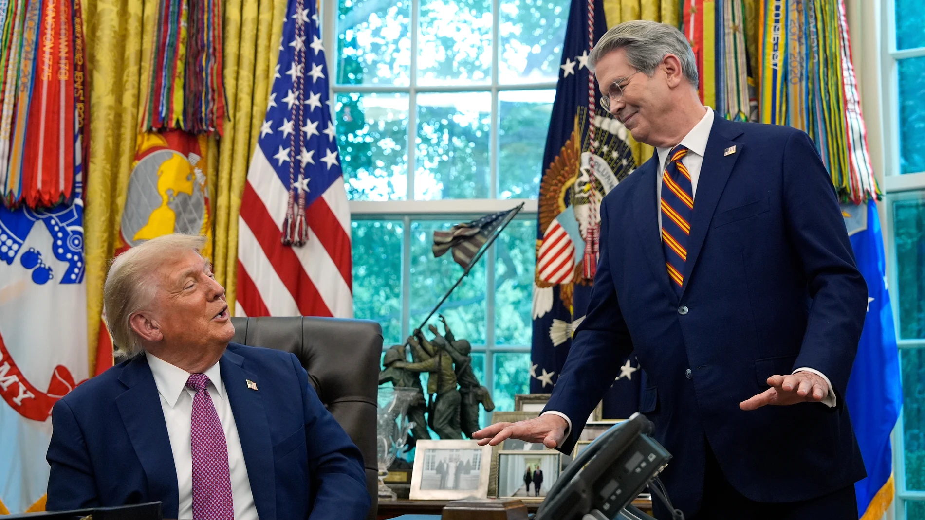 Treasury Secretary Scott Bessent gestures as President Donald Trump speaks in the Oval Office of the White House, Friday, Sept. 5, 2025, in Washington. (AP Photo/Alex Brandon)