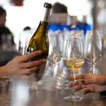 Un camarero sirve vino blanco en un establecimiento de hostelería