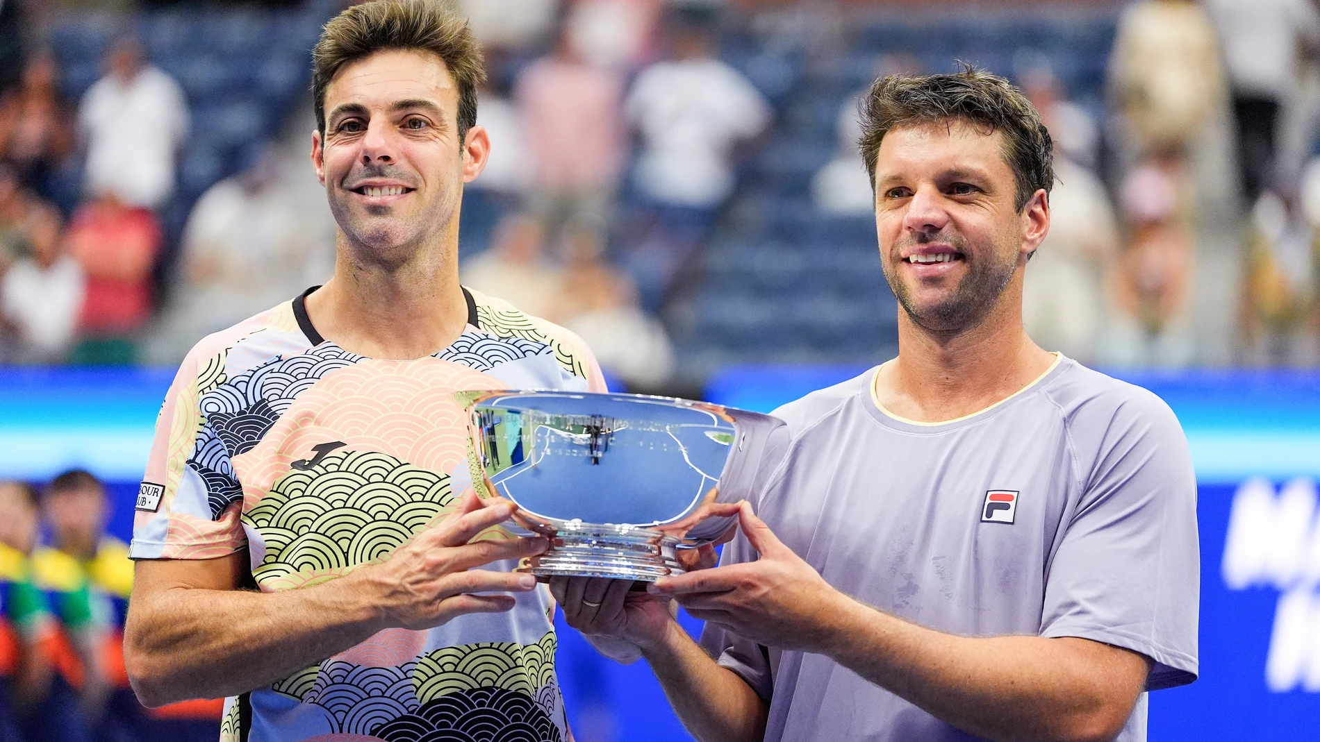 Marcel Granollers, of Spain, left, and Horacio Zeballos, of Argentina, hold the championship trophy after defeating Joe Salisbury, of Great Britain, and Neal Skupski, of Great Britain, in the men's doubles final of the U.S. Open tennis championships, Saturday, Sept. 6, 2025, in New York. (AP Photo/Yuki Iwamura)