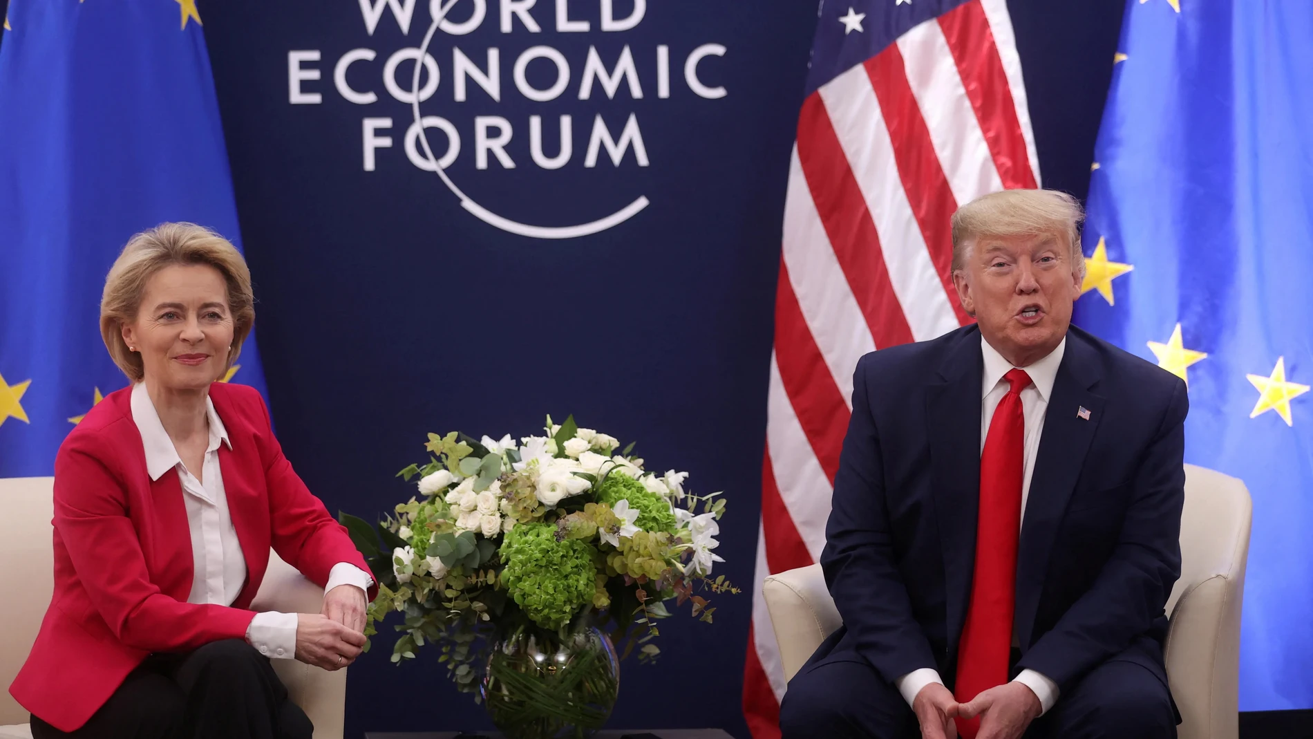 Dos políticos de traje frente a la bandera de la UE y Estados Unidos