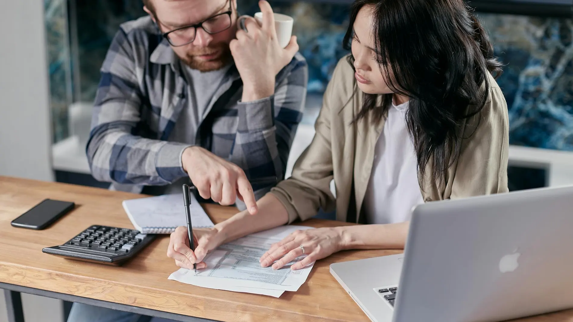 Una pareja revisando qué banco le da más intereses por sus ahorros