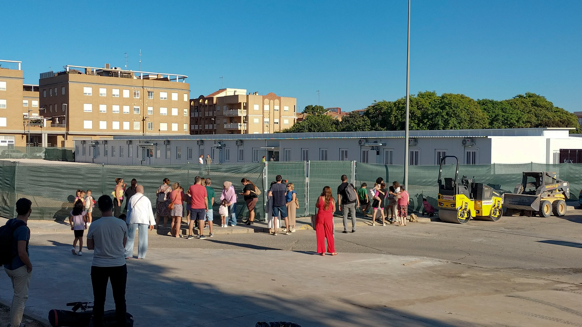 GRAFCVA9176. VALÈNCIA, 11/09/2025.- Un grupo de niños y nilas espera junto a sus padres a las puertas del CEIP Orba de Alfafar para entar en su primer día de clase. El curso escolar 2025/2026 comienza este jueves en los cuatro centros de Algemesí, Alfafar y Massanassa -tres de los municipios más afectados por la dana- que no pudieron hacerlo en las fechas previstas, cuatro días después que el resto de centros de la Comunitat Valenciana. EFE/Eusebio Calatayud