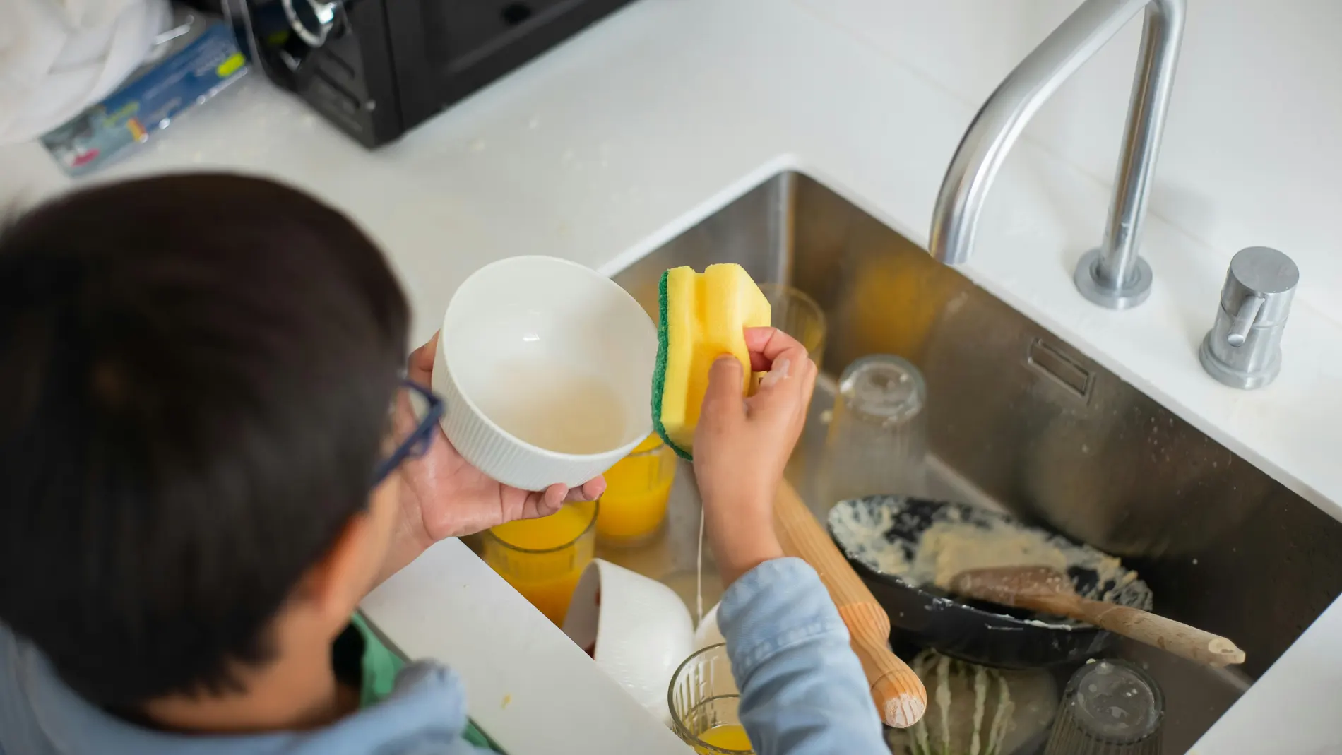 Niño fregando los platos