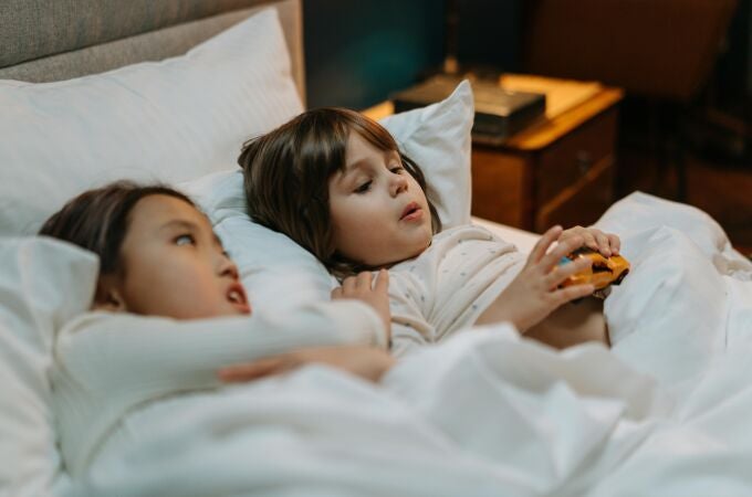 Dos niñas hablando en la cama