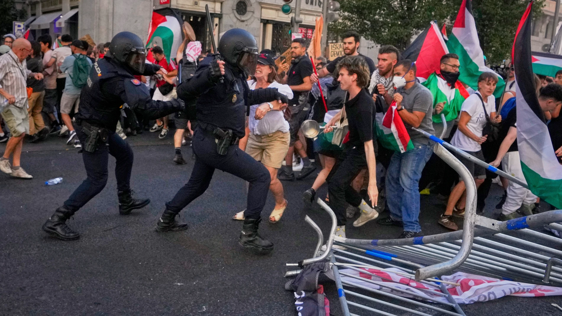 Police try to disperse protesters who block the road in an attempt to disrupt the twenty-first stage of the Spanish cycling race La Vuelta, from Alalpardo to Madrid, Spain, Sunday, Sept. 14, 2025. (AP Photo/Manu Fernández)