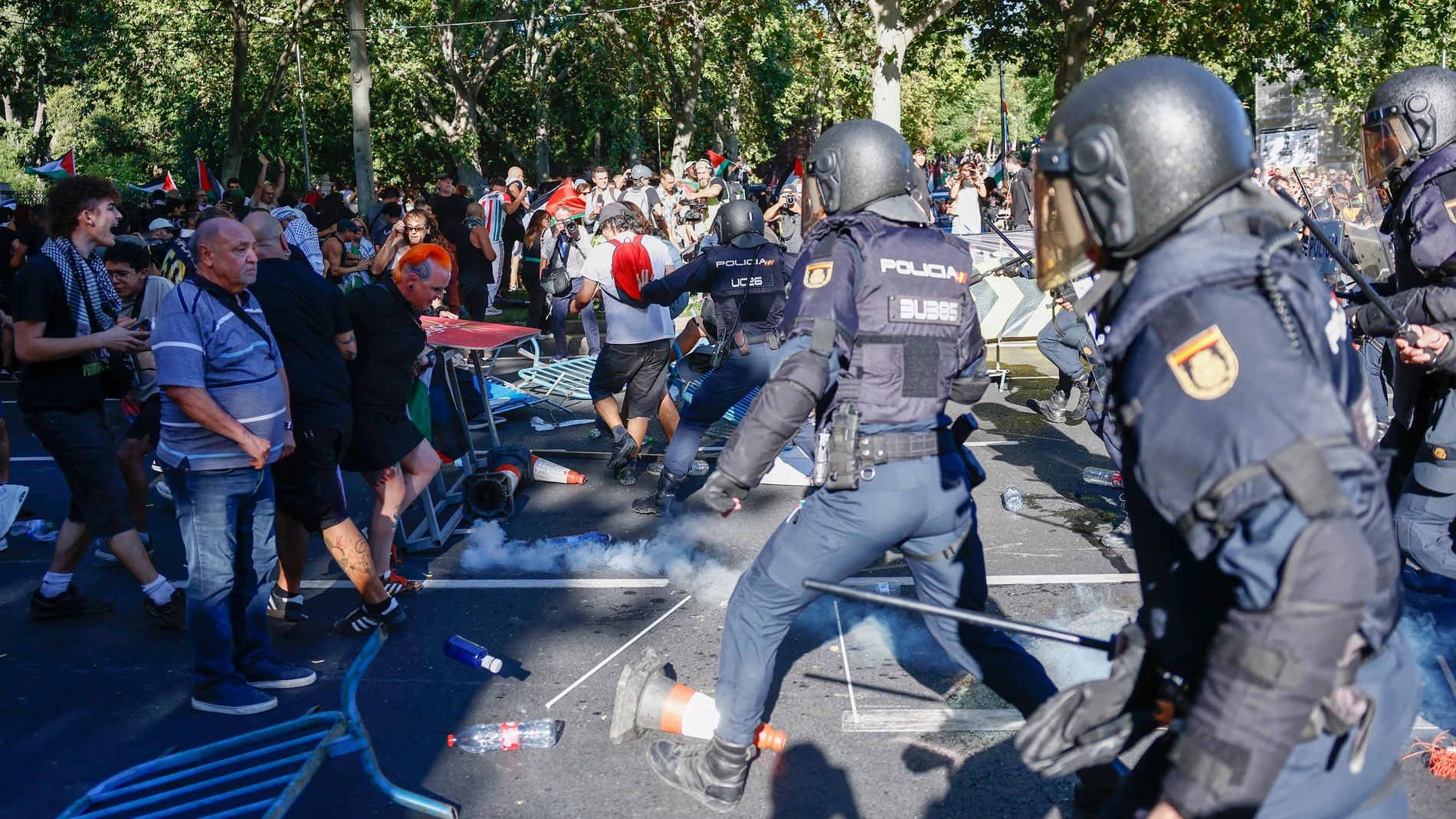 MADRID, 14/09/2025.- La Policía realiza cargas contra los manifestantes propalestinos con el objetivo de despejar el recorrido de los ciclistas en el Paseo del Prado, este domingo, durante la última etapa de la Vuelta a España que se disputa entre las localidades madrileñas de Alalpardo y Madrid, con un recorrido 103,6 Km.- EFE/Rodrigo Jiménez