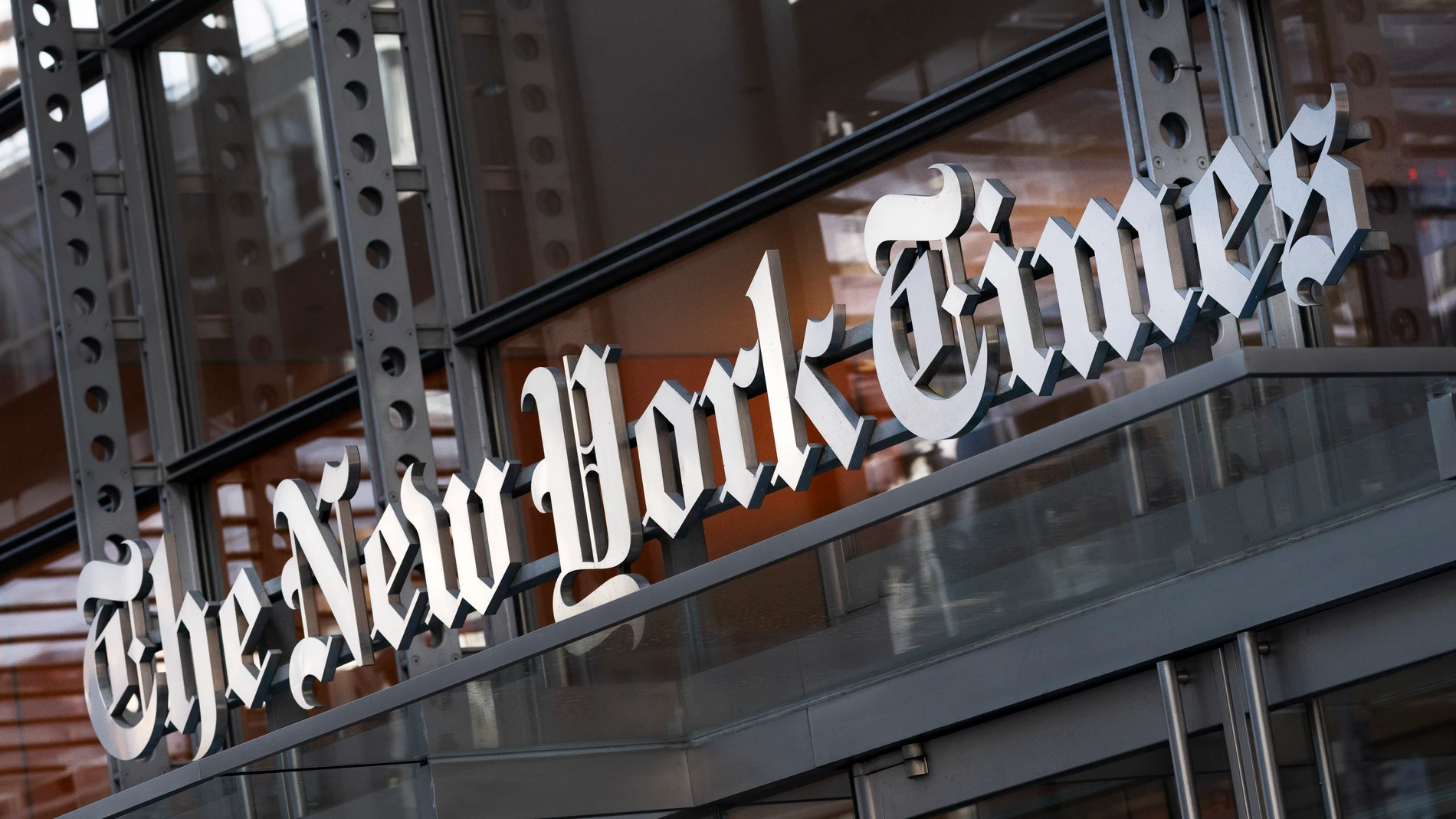 FILE - A sign for The New York Times hangs above the entrance to its building, May 6, 2021, in New York. (AP Photo/Mark Lennihan, File)