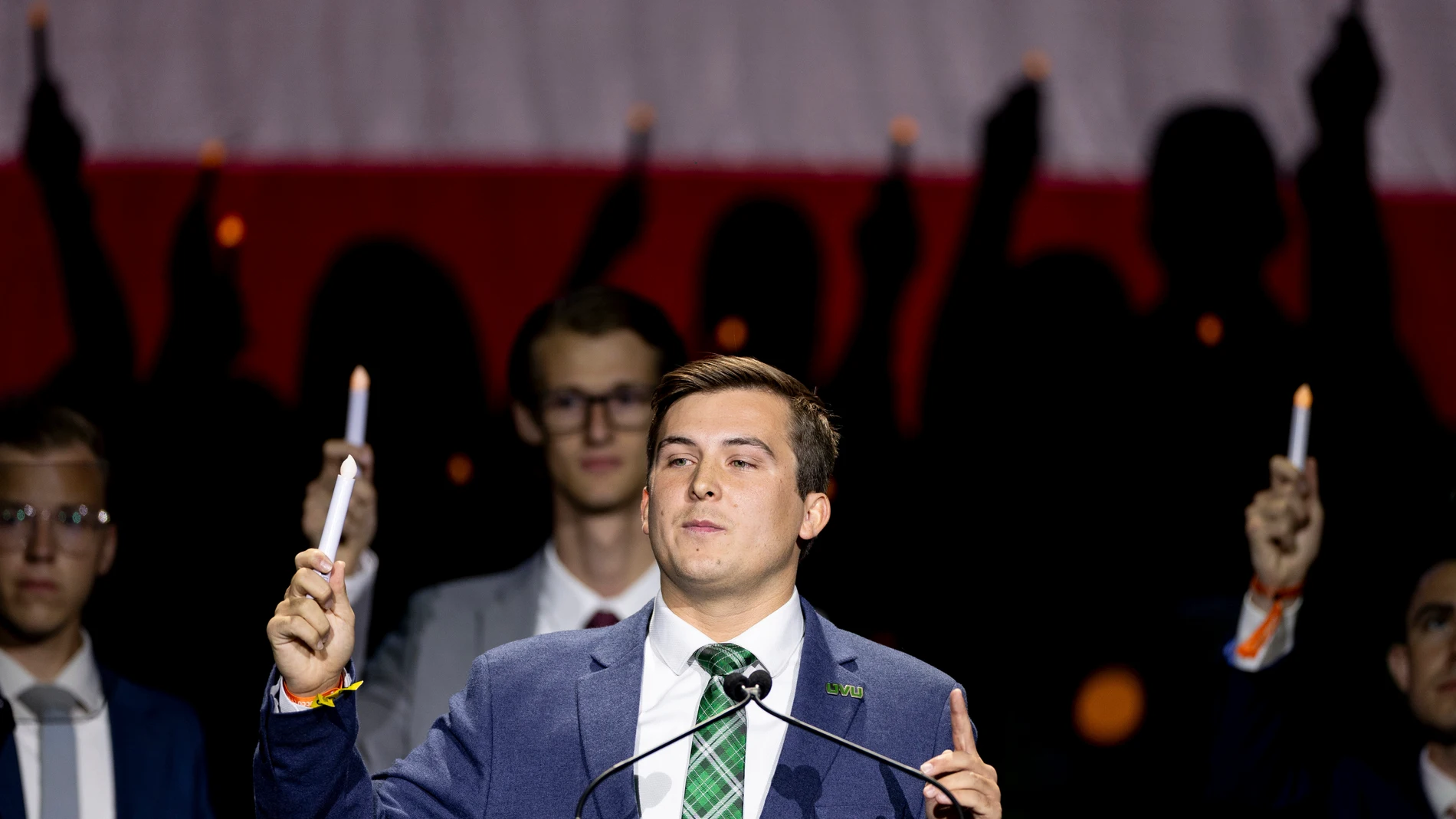 Representatives from Utah universities stand behind Utah Valley University Student Body President Kyle Cullimore as he holds up a candle after giving closing remarks during the Vigil for Unity at the UCCU Center at Utah Valley University in Orem on Friday, Sept. 19, 2025. Charlie Kirk, conservative activist and the founder and president of Turning Point USA, was fatally shot while answering questions at his American Comeback Tour at UVU on Sept. 10. (Rio Giancarlo/The Deseret News via AP)/The...