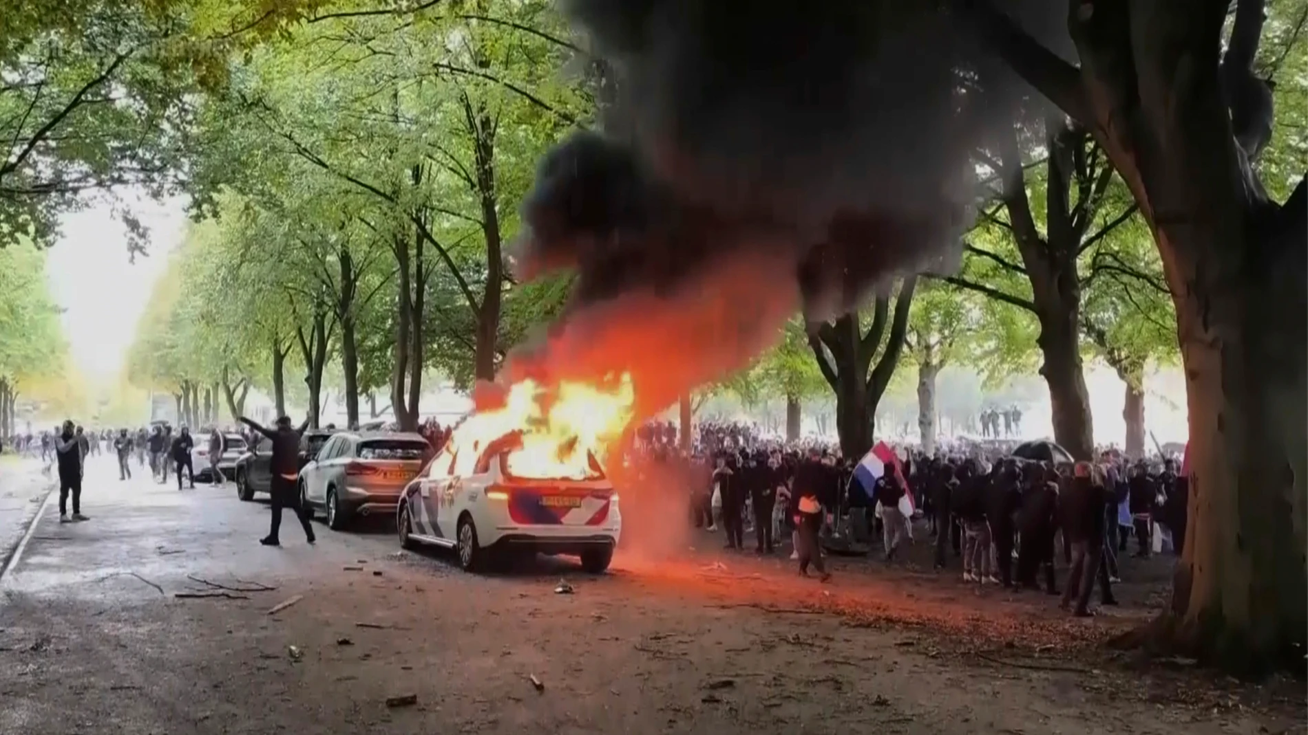A police vehicle burns as a right-wing demonstration erupted into violence and chaos as rioters clashed with police on Saturday, Sept. 20, 2025 in The Hague, Netherlands. (REGIO8 via AP)
