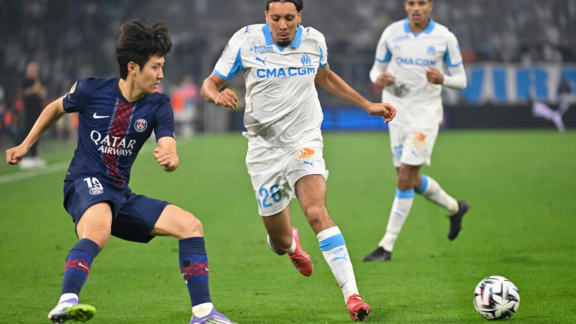 PSG's Lee Kang-in, left, challenges for the ball with Marseille's Bilal Nadir during the French League One soccer match between Marseille and Paris Saint-Germain at Orange Velodrome in Marseille, France, Monday, Sept. 22, 2025. (AP Photo/Philippe Magoni)