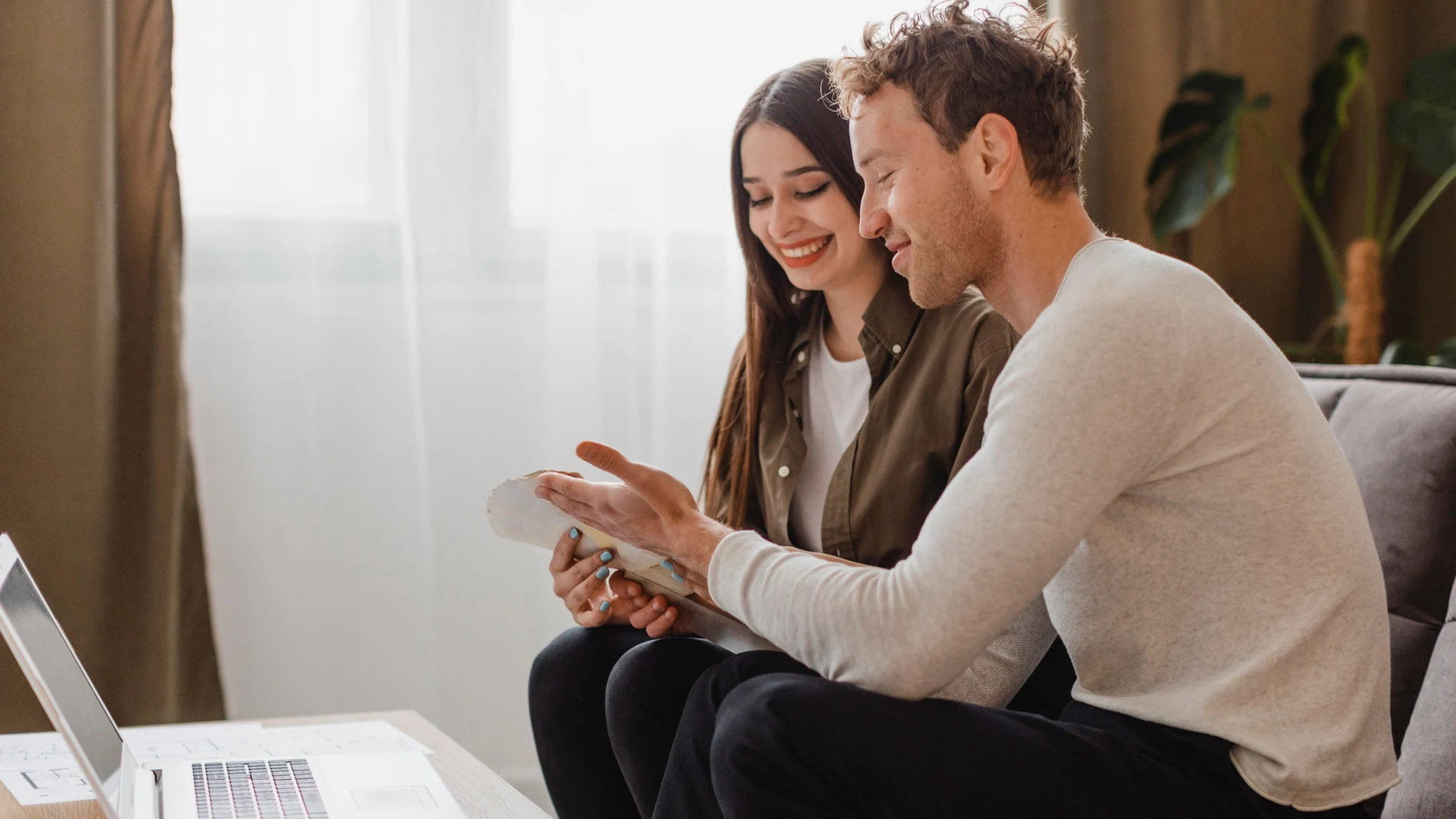Vista lateral de la pareja haciendo planes para diversificar tus ahorros en varias cuentas remuneradas
