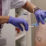 Imagen de un sanitario poniendo una vacuna