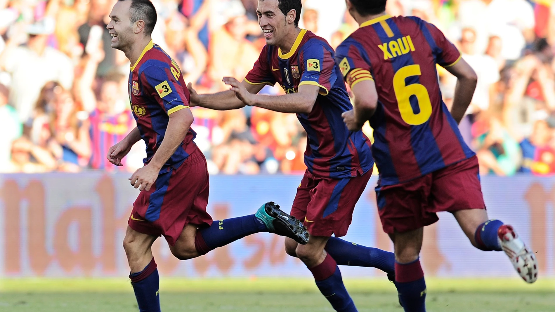 FILE - Barcelona's Andres Iniesta, left, is congratulated by teammates Sergio Busquets, center, and Xavi Hernandez after scoring against Racing de Santander during their Spanish La Liga soccer match at El Sardinero stadium in Santander, northern Spain Sunday Aug. 29, 2010. (AP Photo/Alvaro Barrientos, File)