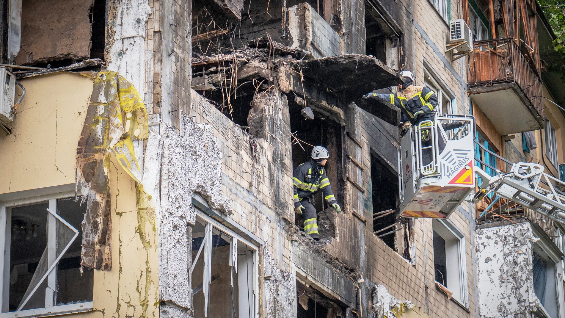Rescuers work at the site of an apartment buildings damaged during a Russian attack in Kyiv, Ukraine, Sunday, Sept. 28, 2025. (AP Photo/Dan Bashakov)