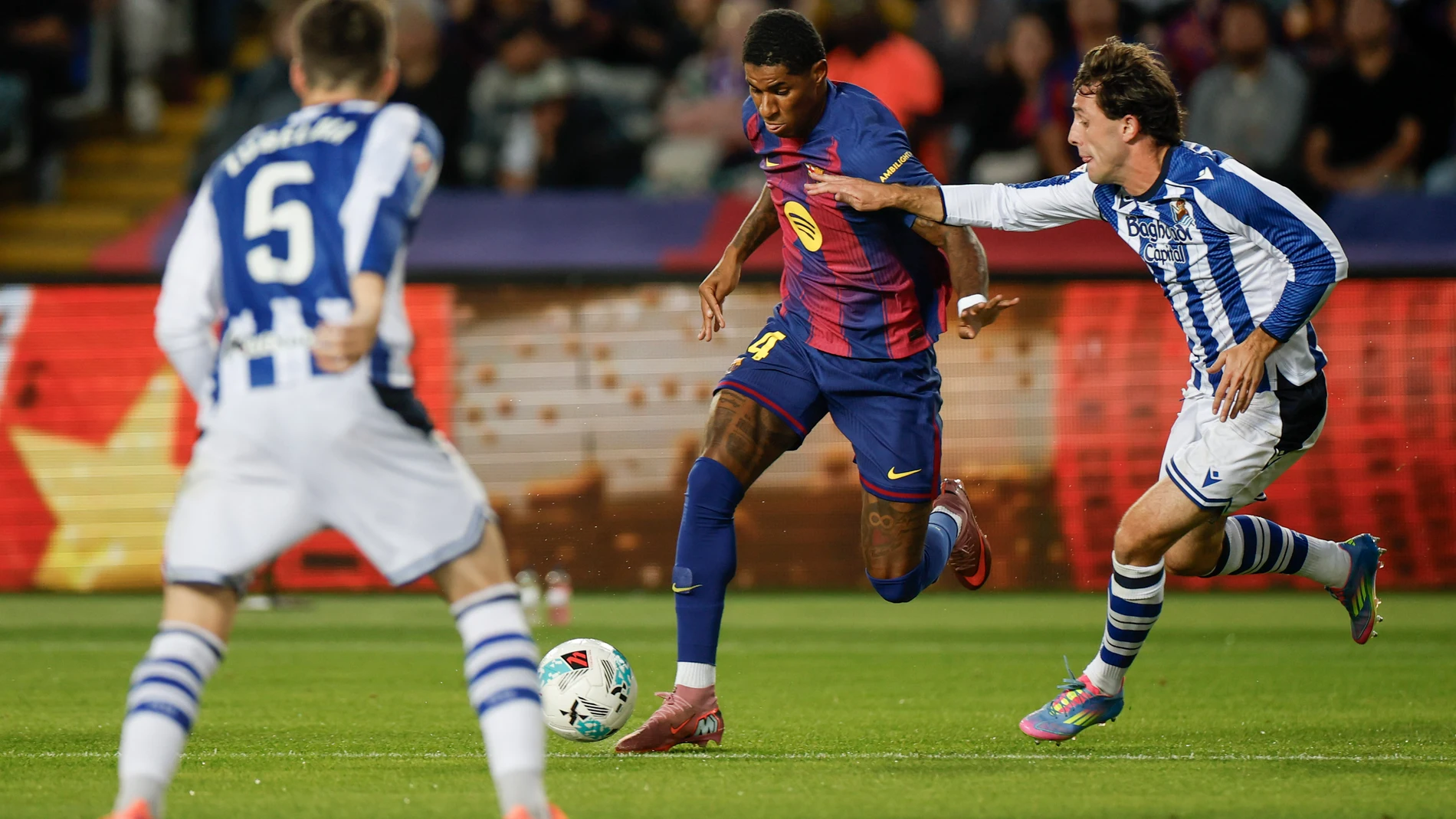 BARCELONA, 28/09/2025.- El delantero británico del FC Barcelona, Marcus Rashford (2d), se lleva el balón ante el defensa de la Real Sociedad, Álvaro Odriozola, durante el encuentro correspondiente a la séptima jornada de Liga EA Sports que FC Barcelona y Real Sociedad disputan este domingo en el estadio de Montjuic, en Barcelona. EFE/Alberto Estevez.