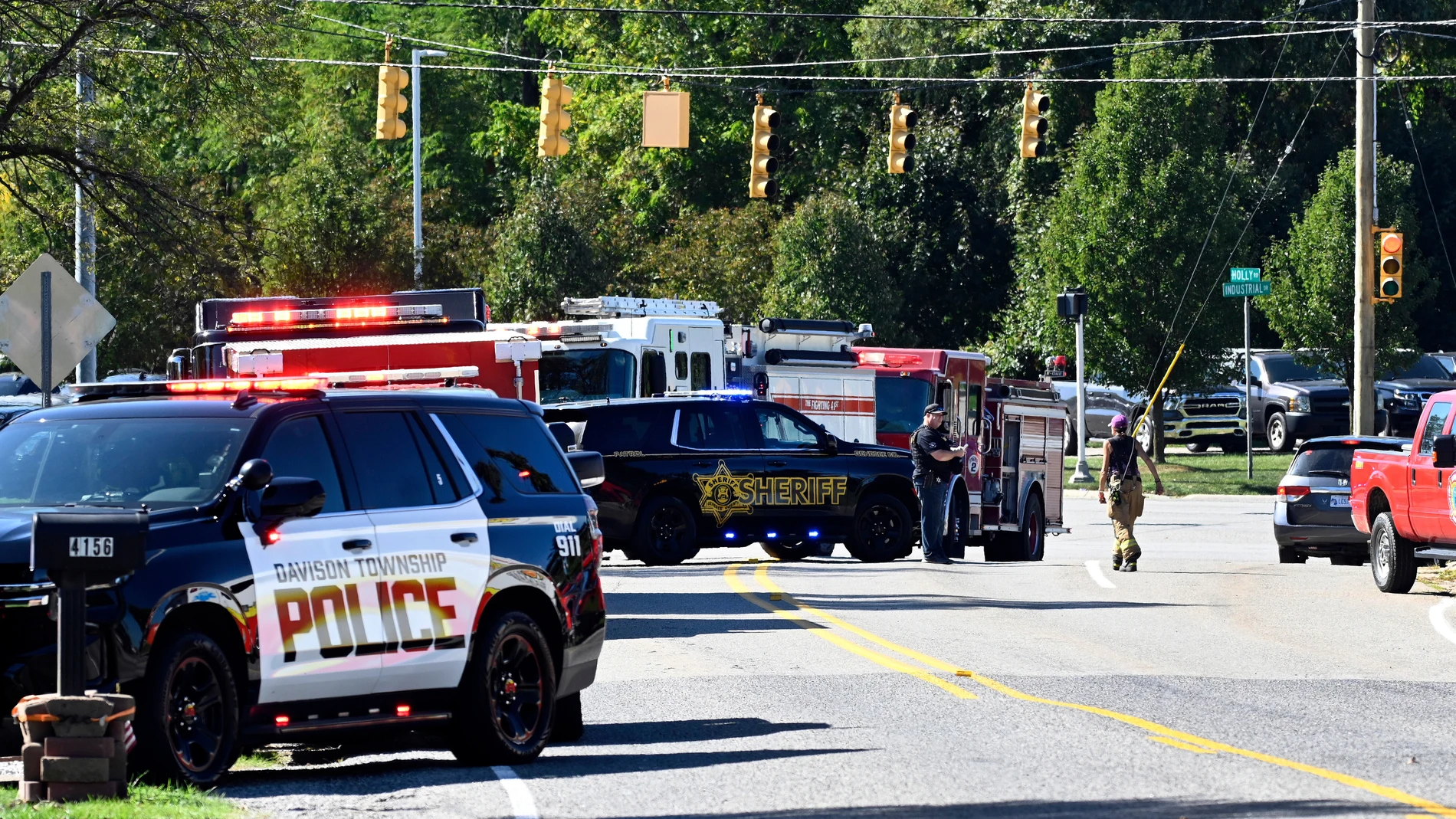 Law enforcement and fire personnel stand near the corner of McCandlish and Holly road, near a shooting that took place at The Church of Jesus Christ of Latter-day Saints, Sunday, Sept. 28, 2025, in Grand Blanc, Mich. (AP Photo/Jose Juarez)
