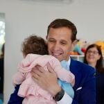 Conrado Íscar coge a un bebé en brazos durante su visita a La escuela infantil ‘Virgen de Castilviejo’ de Medina del Rioseco
