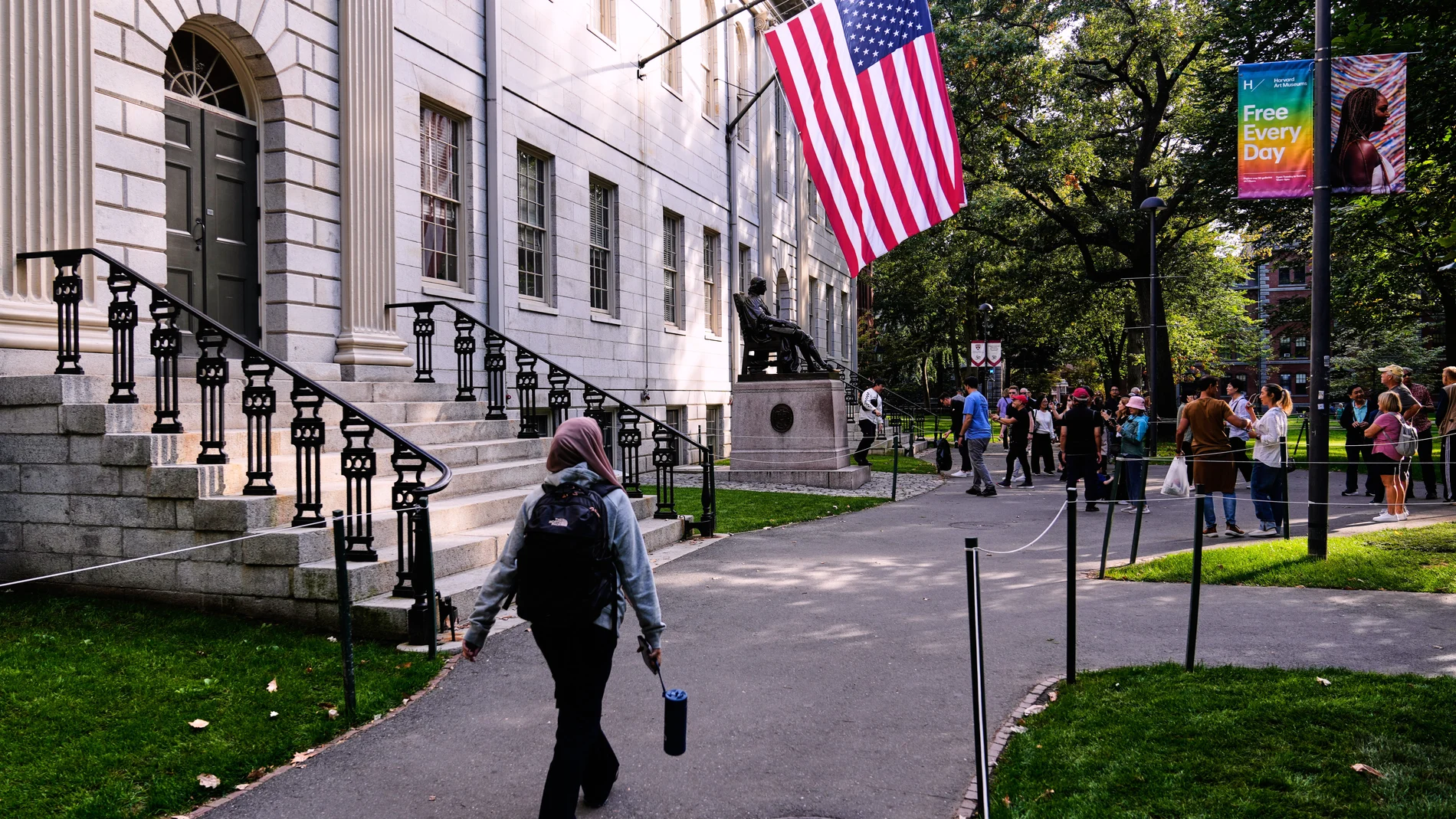 A woman walks through Harvard Yard at Harvard University, Tuesday, Sept. 30, 2025, in Cambridge, Mass. (AP Photo/Charles Krupa)