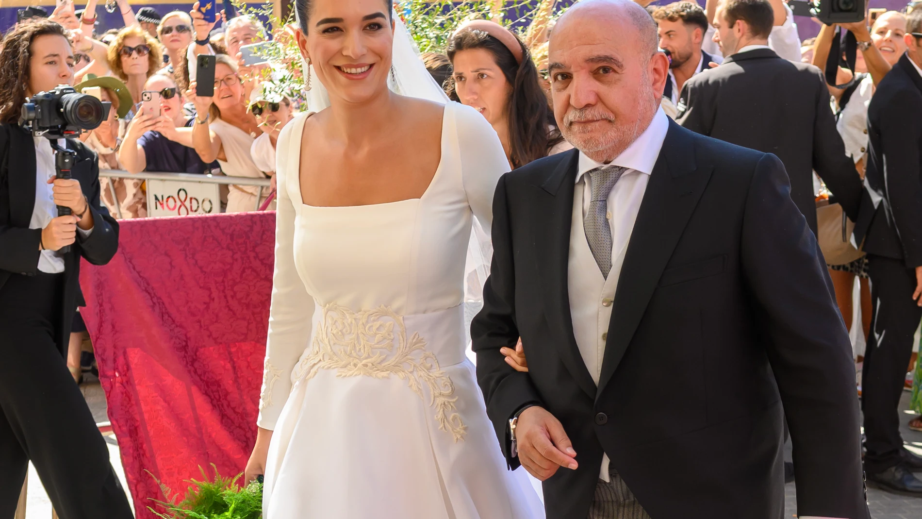 SEVILLA. 04/10/2025. - La novia Bárbara Mirjan, acompañada de su padre, llega a la Iglesia de los Gitanos para contraer matrimonio con Cayetano Martínez de Irujo este sábado en Sevilla. EFE/ Raúl Caro
