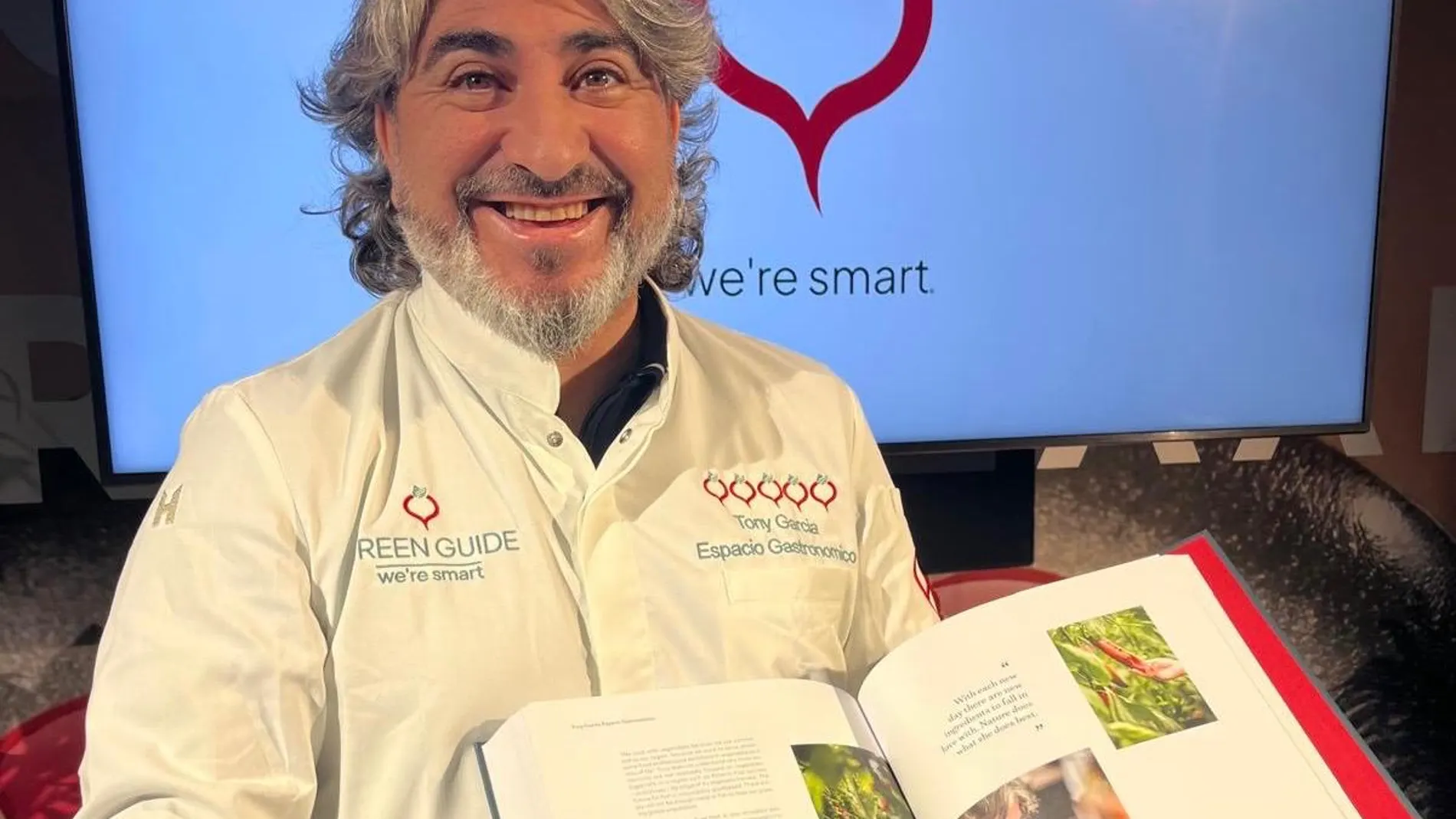 El chef Tony García posa junto a las páginas en las que aparece del nuevo libro presentado en Países Bajos
