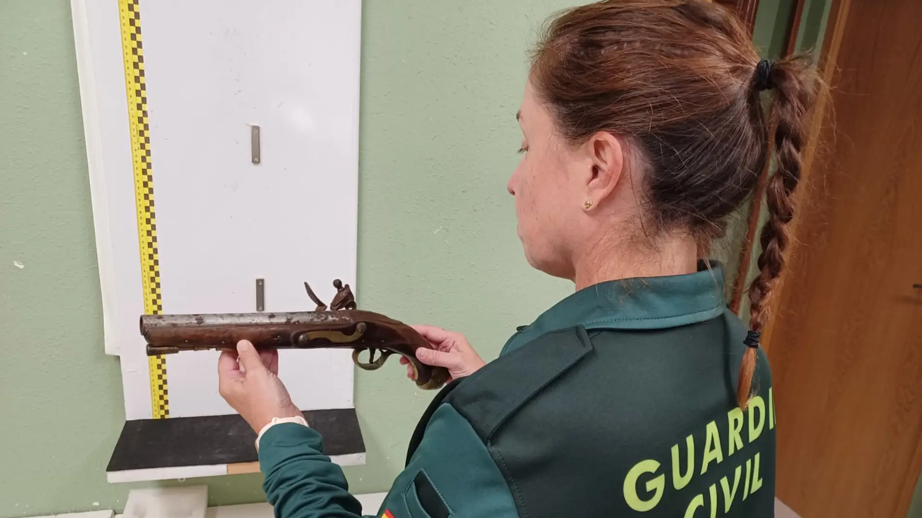 Una agente de la Guardia Civil con el arma incautada