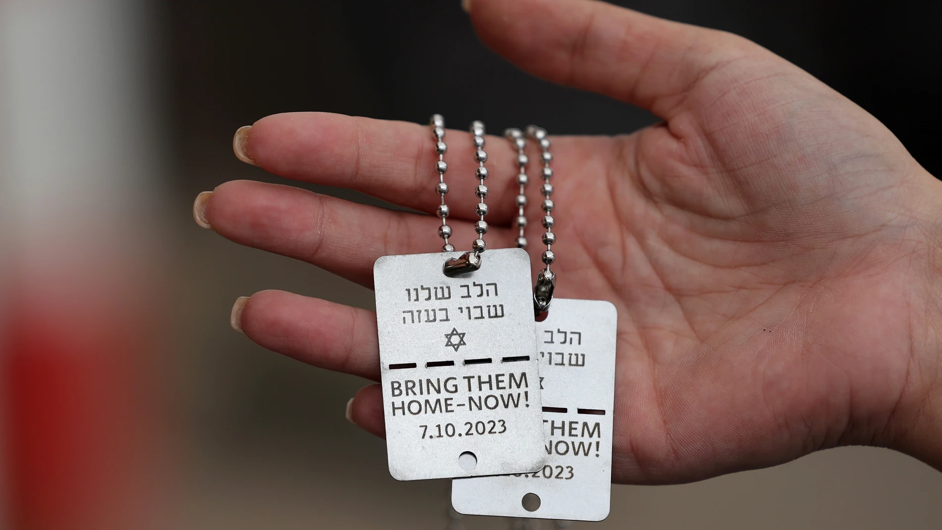 Revivim (Israel), 06/10/2025.- (FILE) - An Israeli woman holds military identification tags with the inscriptions 'Our heart are captive in Gaza' (top) and 'Bring them home 7.10.2023' (bottom), outside a kiosk near Kibbutz Revivim, southern Israel, 15 November 2023 (reissued 06 October 2025). 07 October 2025 marks two years since the Palestinian militant group Hamas launched a surprise attack on Israel, taking dozens of hostages and killing nearly 1,200 people. In response, Israel began its w...