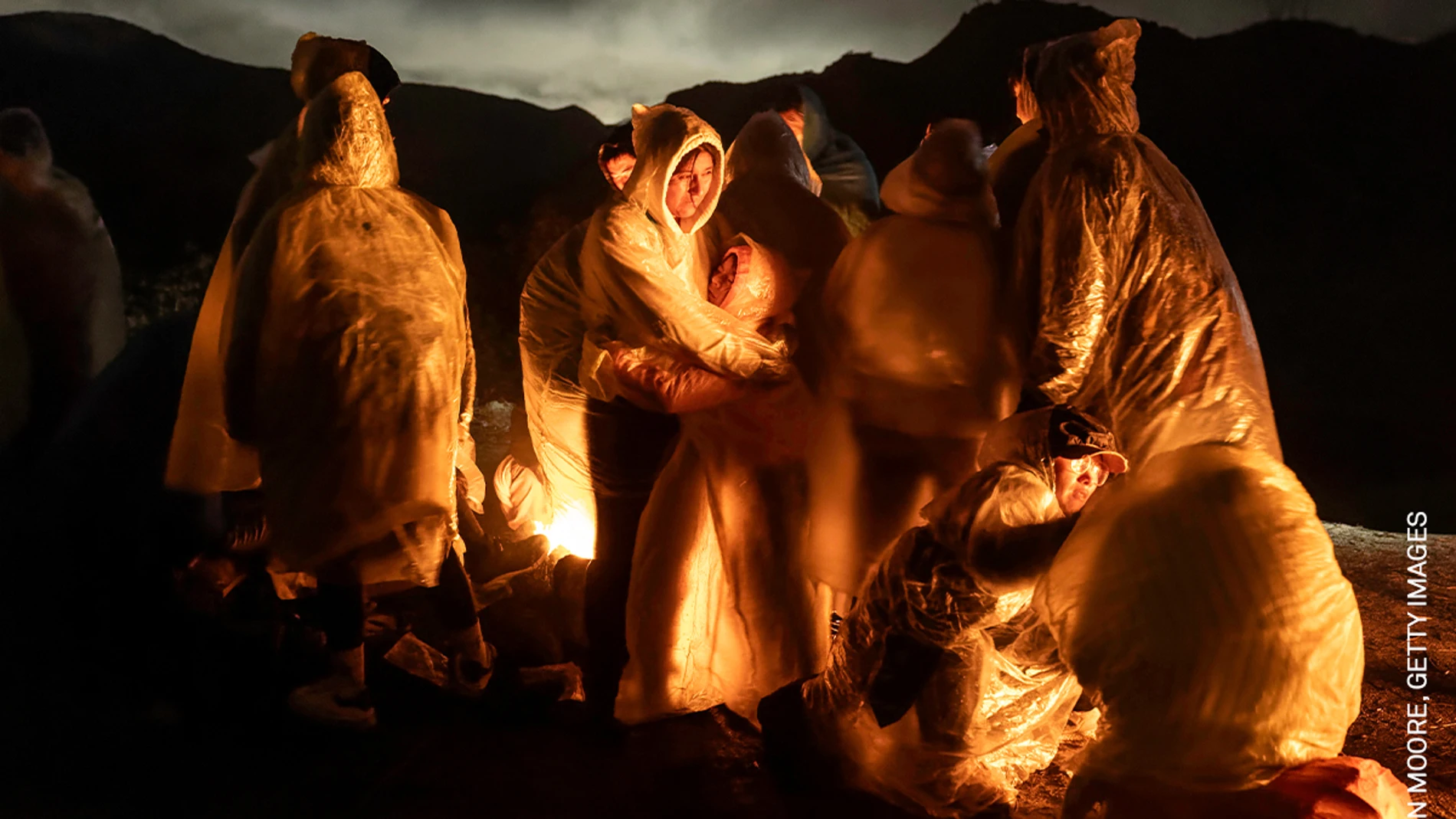 La fotografía «Cruzar de noche», de John Moore, que recoge cómo migrantes chinos entran en calor bajo una fría lluvia tras cruzar la frontera