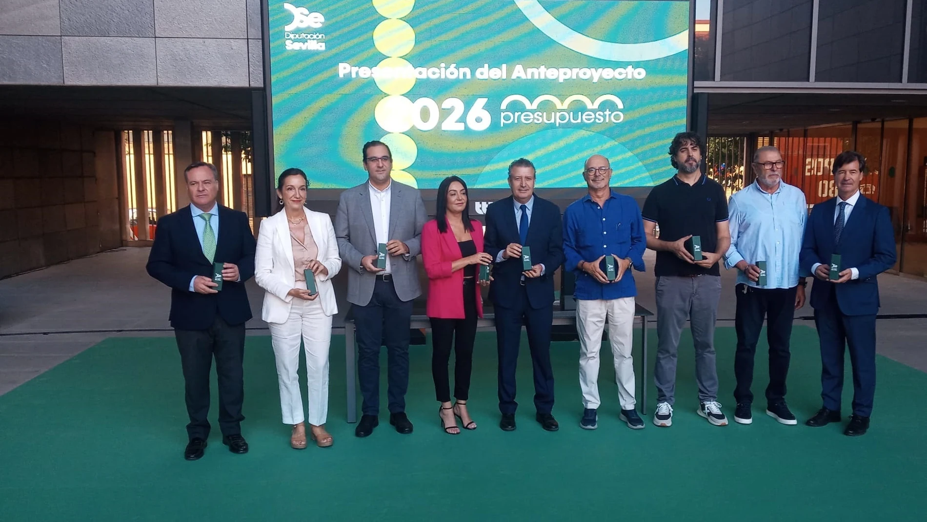 Foto de familia del presidente de la Diputación y de la diputada de Hacienda, en el centro, con los portavoces de los grupos políticos y representantes de los agentes sociales