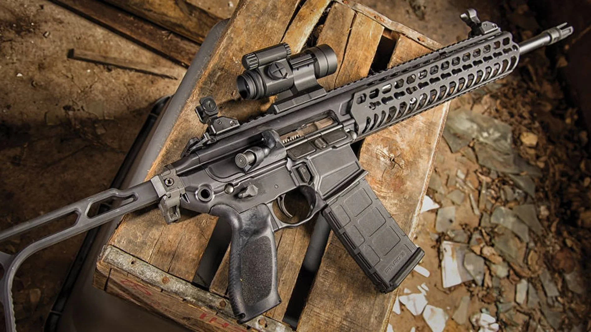 Fusil de asalto de color negro colocado encima de una caja de madera