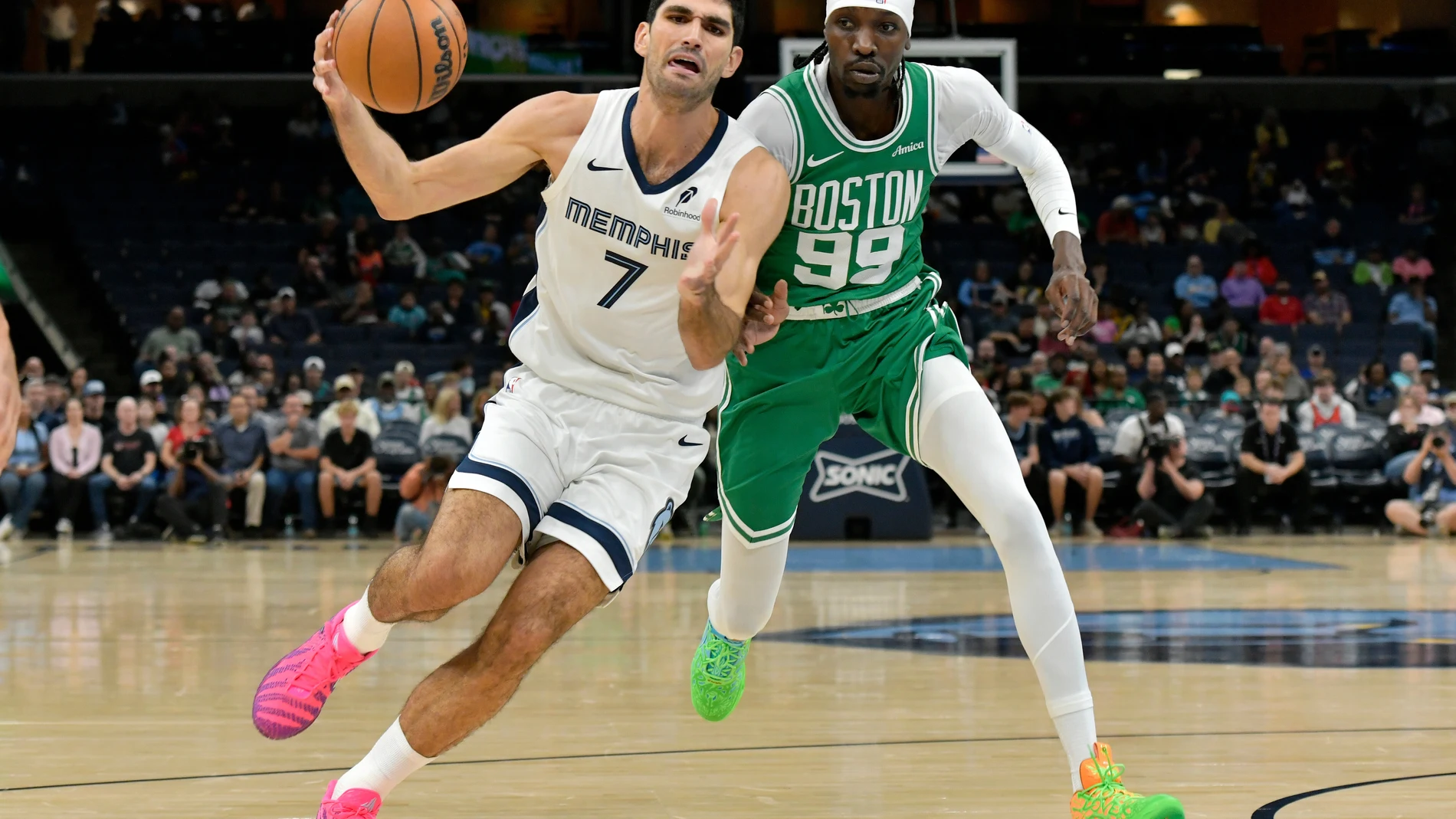 Memphis Grizzlies forward Santi Aldama (7) drives against Boston Celtics forward Chris Boucher (99) in the first half of an NBA basketball preseason game Wednesday, Oct. 8, 2025, in Memphis, Tenn. (AP Photo/Brandon Dill)