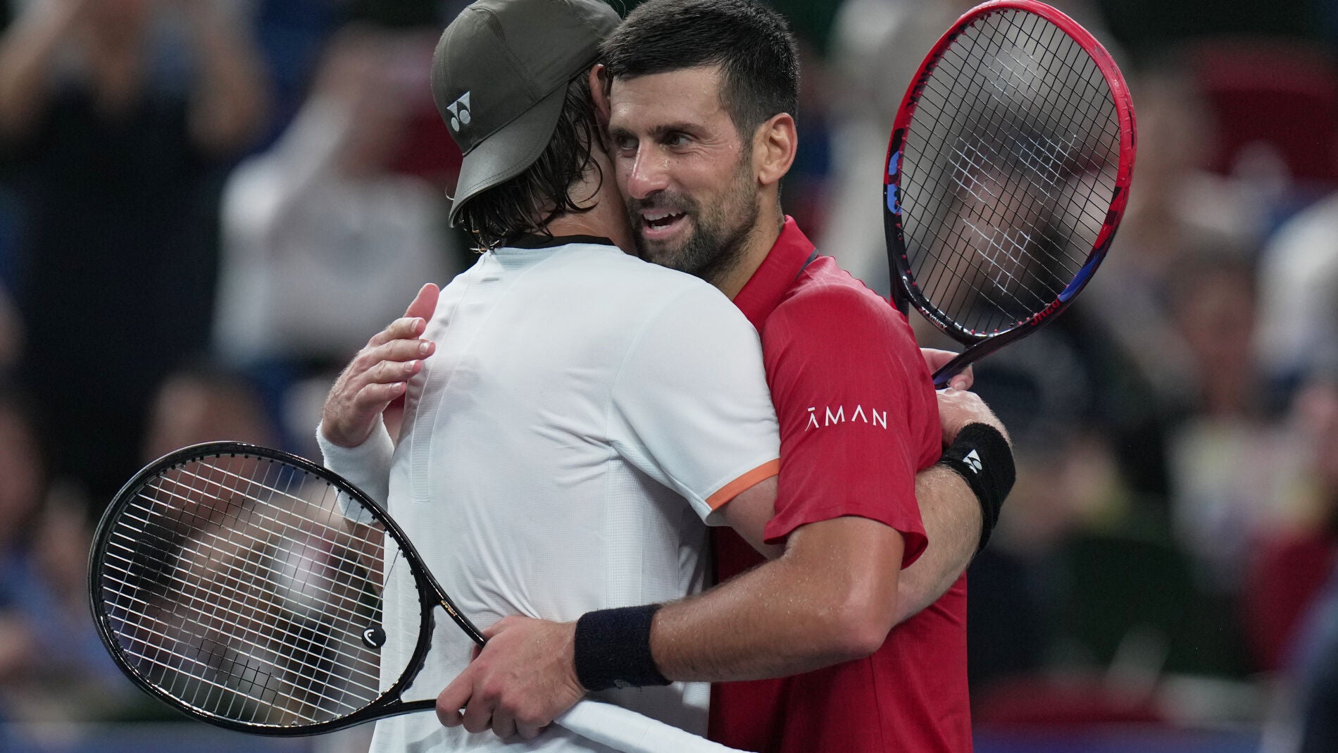 Novak Djokovic of Serbia, right, hugs Zizou Bergs of Belgium, left, after their men's singles quarterfinal match of the Shanghai Masters tennis tournament at Qizhong Forest Sports City Tennis Center, in Shanghai, China, Thursday, Oct. 9, 2025. (AP Photo/Andy Wong)