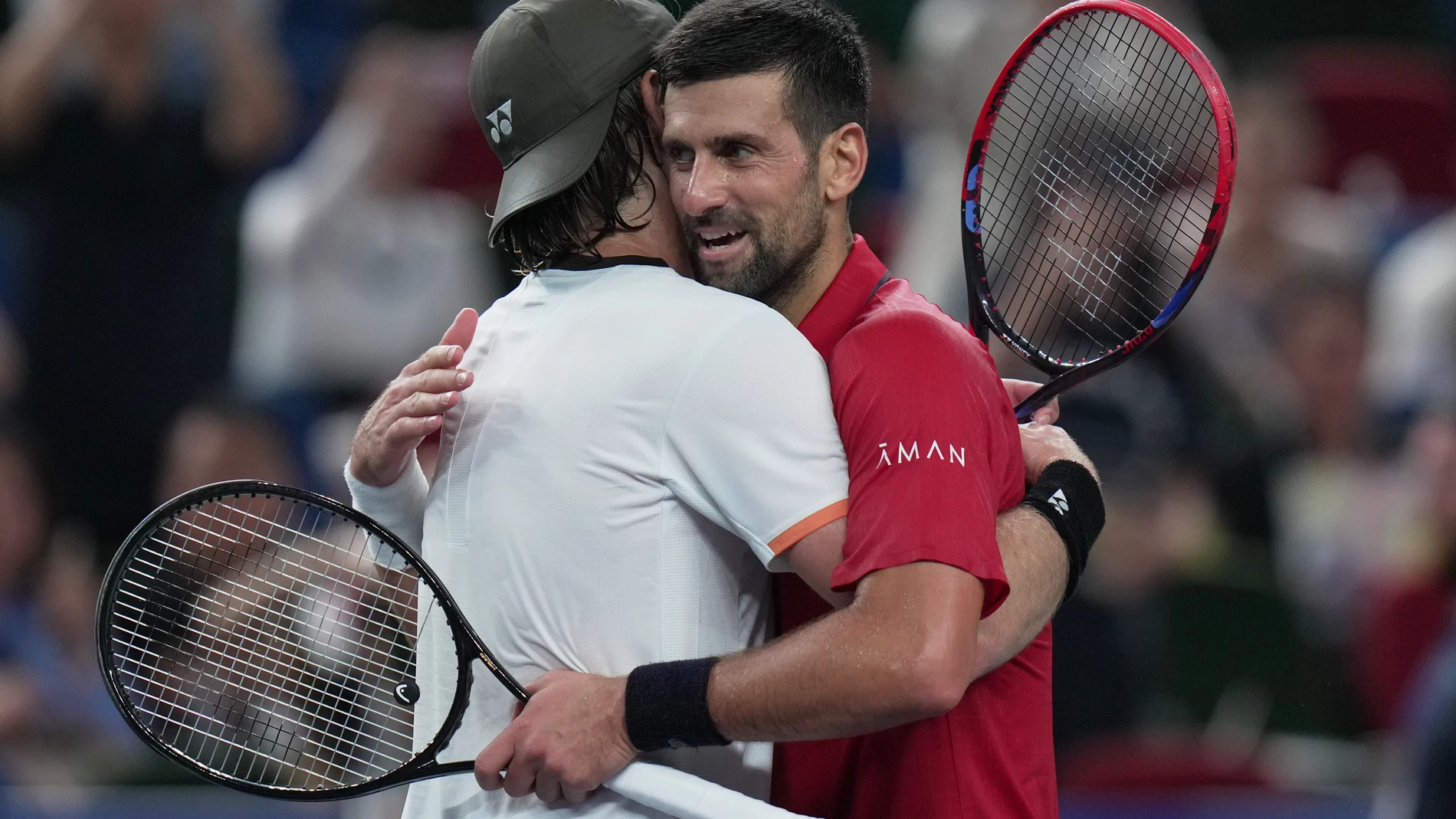 Novak Djokovic of Serbia, right, hugs Zizou Bergs of Belgium, left, after their men's singles quarterfinal match of the Shanghai Masters tennis tournament at Qizhong Forest Sports City Tennis Center, in Shanghai, China, Thursday, Oct. 9, 2025. (AP Photo/Andy Wong)
