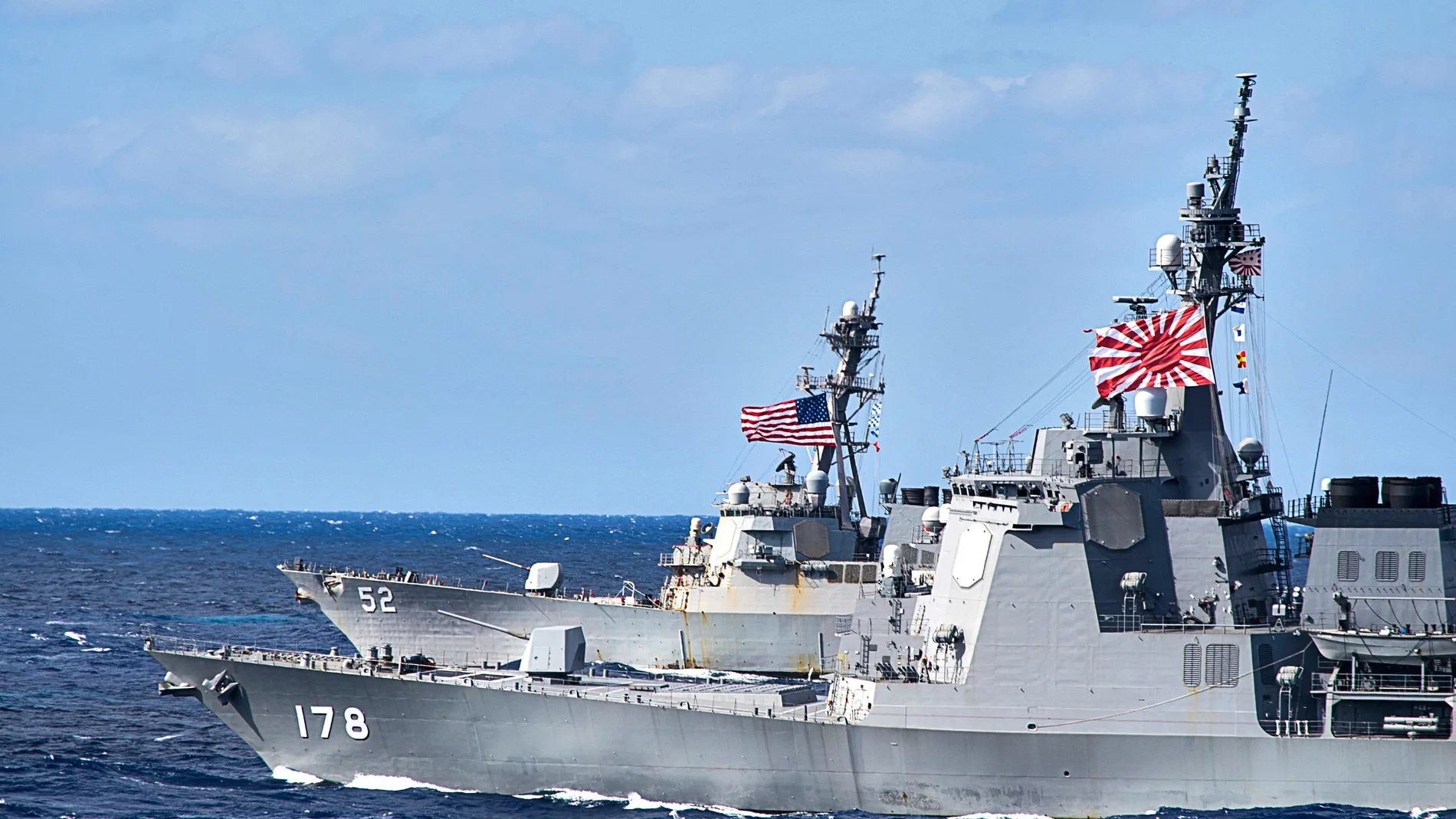 Dos buques, uno con la bandera de Estados Unidos y otro con la bandera de Japón en alta mar