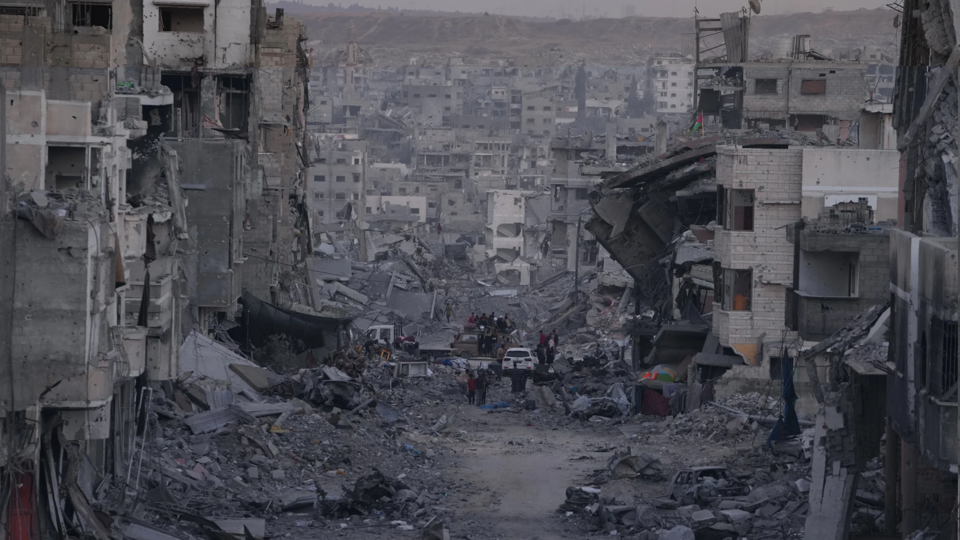 Palestinians walk among destroyed buildings in Gaza City, Sunday, Oct. 12, 2025, after Israel and Hamas agreed to a pause in their war and the release of the remaining hostages. (AP Photo/Jehad Alshrafi)