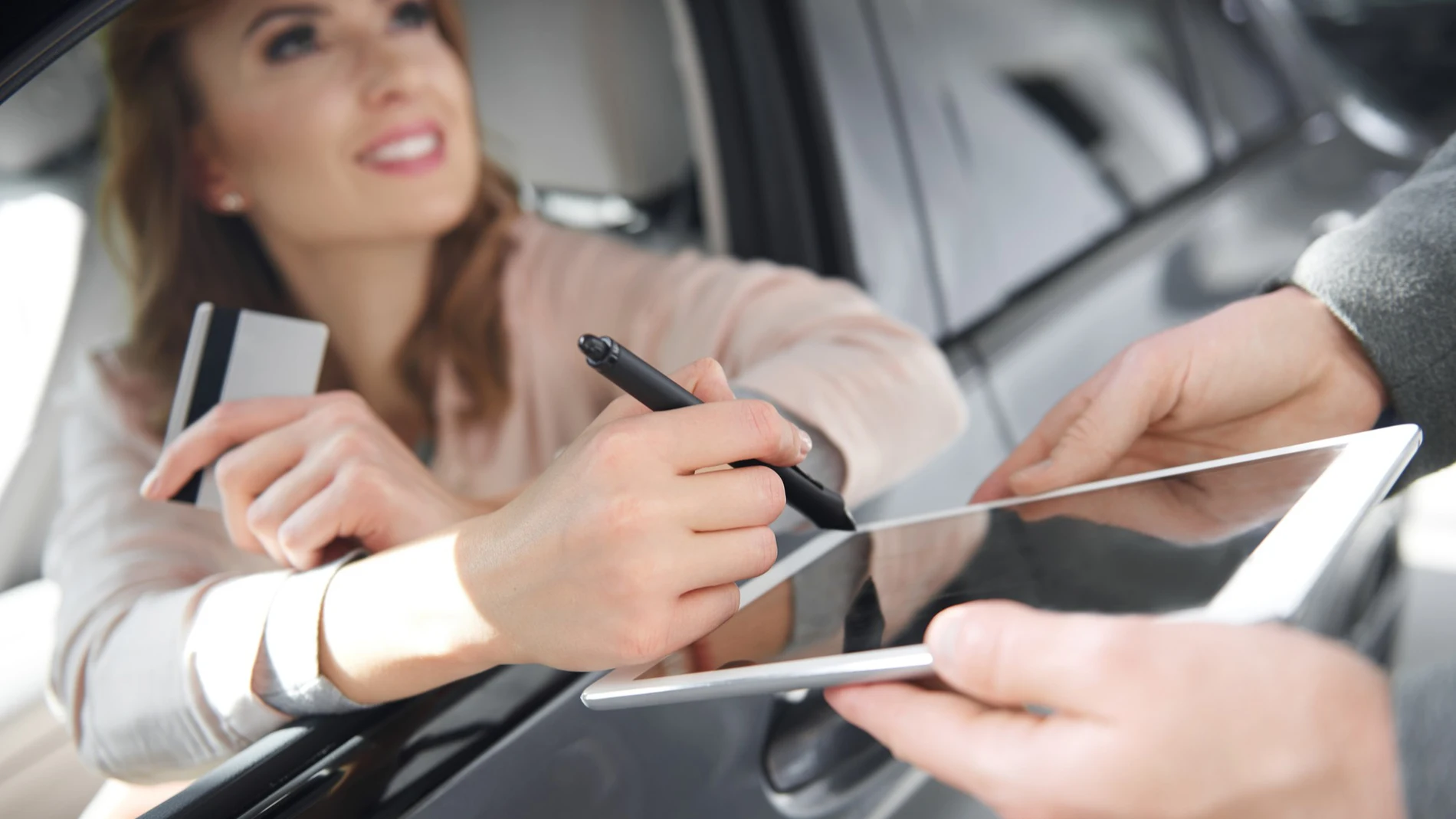 Mujer recibiendo un crédito con coche como aval: cómo funcionan y qué riesgos implican